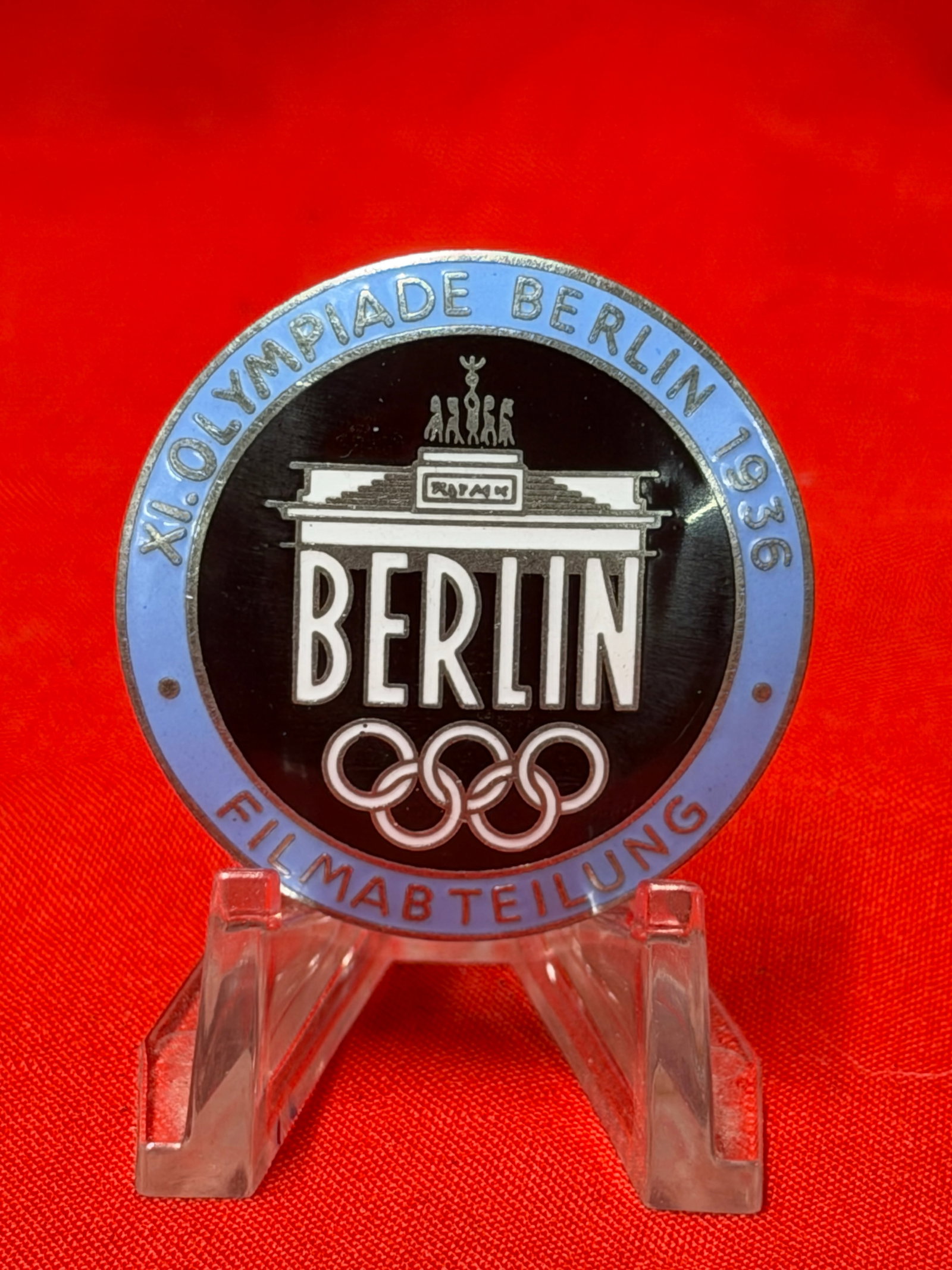WW2 1936 Berlin Olympic Games Film Department XI Olympiade Berlin Pin Badge Rob Neff: 1936 Berlin Olympic Games film department pin badge featuring Berlin Olympic rings and Brandenburg Gate design with blue enamel border marked XI Olympiade Berlin 1936 Filmabteilung. Reverse retains fu
