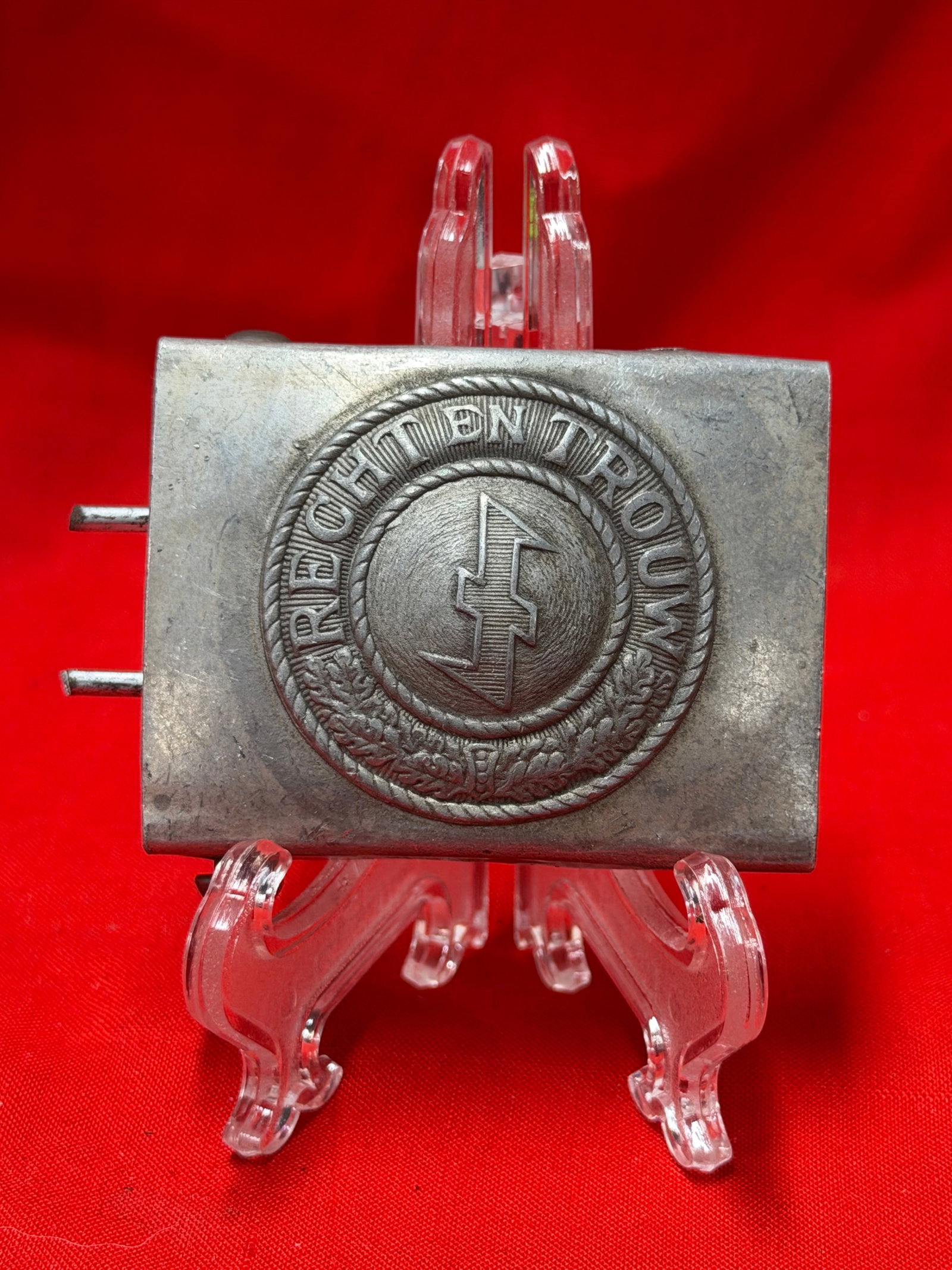 WW2 German Reichsbund Belt Buckle Marked R.Z.M. M9/12 Metal Uniform Buckle: Metal belt buckle featuring Reichsbund emblem with detailed wreath border and central insignia design. Reverse side shows R.Z.M. M9/12 markings along with attached belt hardware. In our opinion this i
