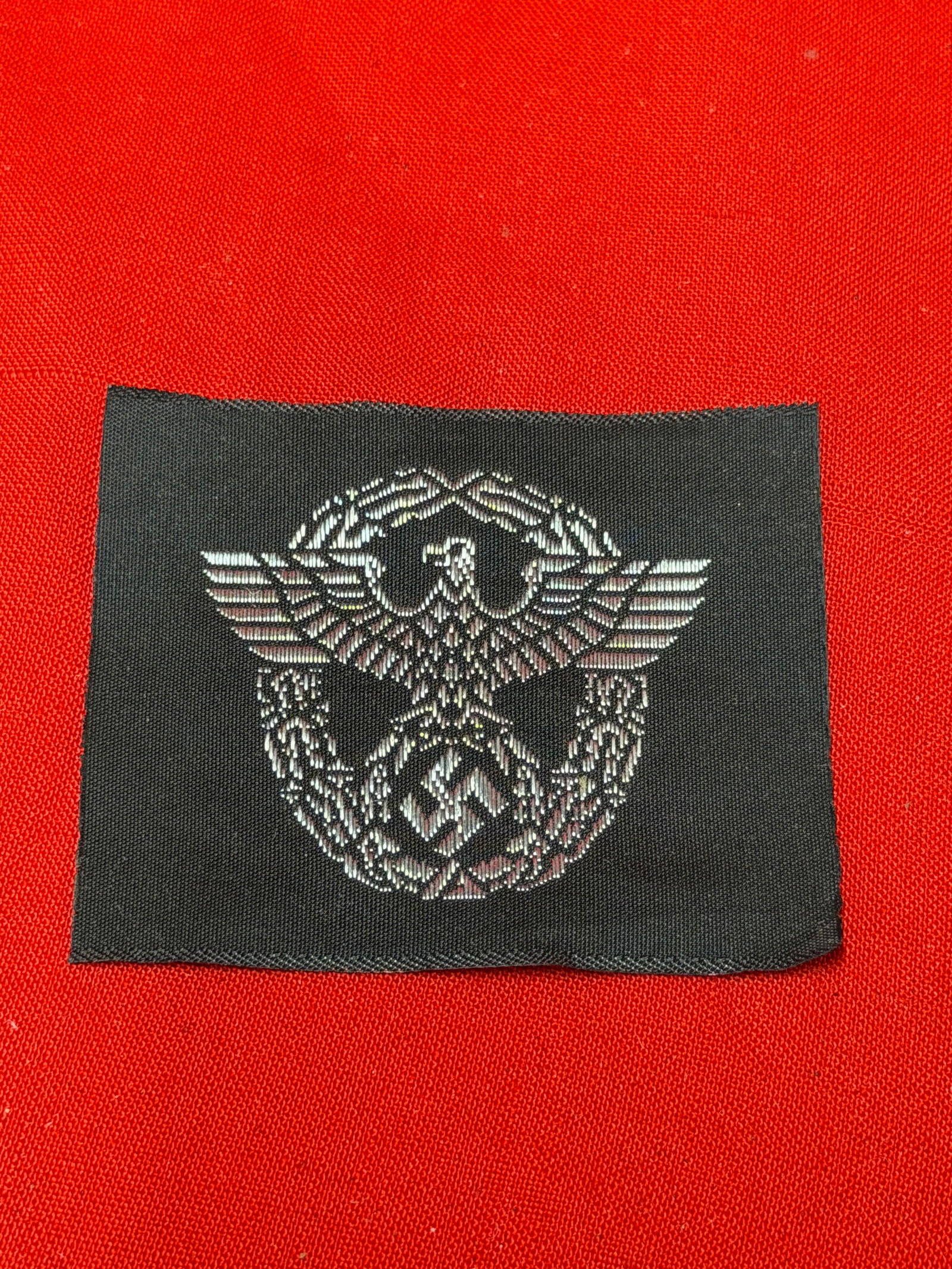WWII German Third Reich Police / SS-Style BeVo Woven Uniform Insignia Patch Lot: World War II era German Third Reich woven uniform insignia patches featuring eagle-and-wreath designs with black woven backing and silver-gray thread detail. Includes two separate BeVo-style woven ins