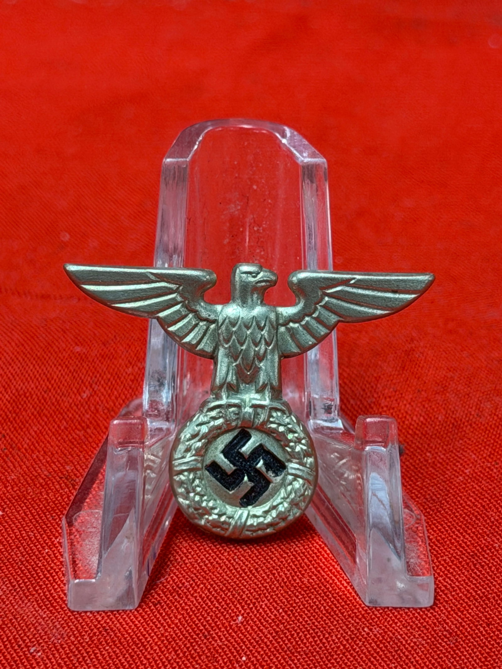 WWII German Political Eagle Cap Insignia Pin: World War II era German political eagle cap insignia pin featuring spread-wing eagle above circular wreath with black center emblem. This type of eagle was often associated with NSDAP political organi