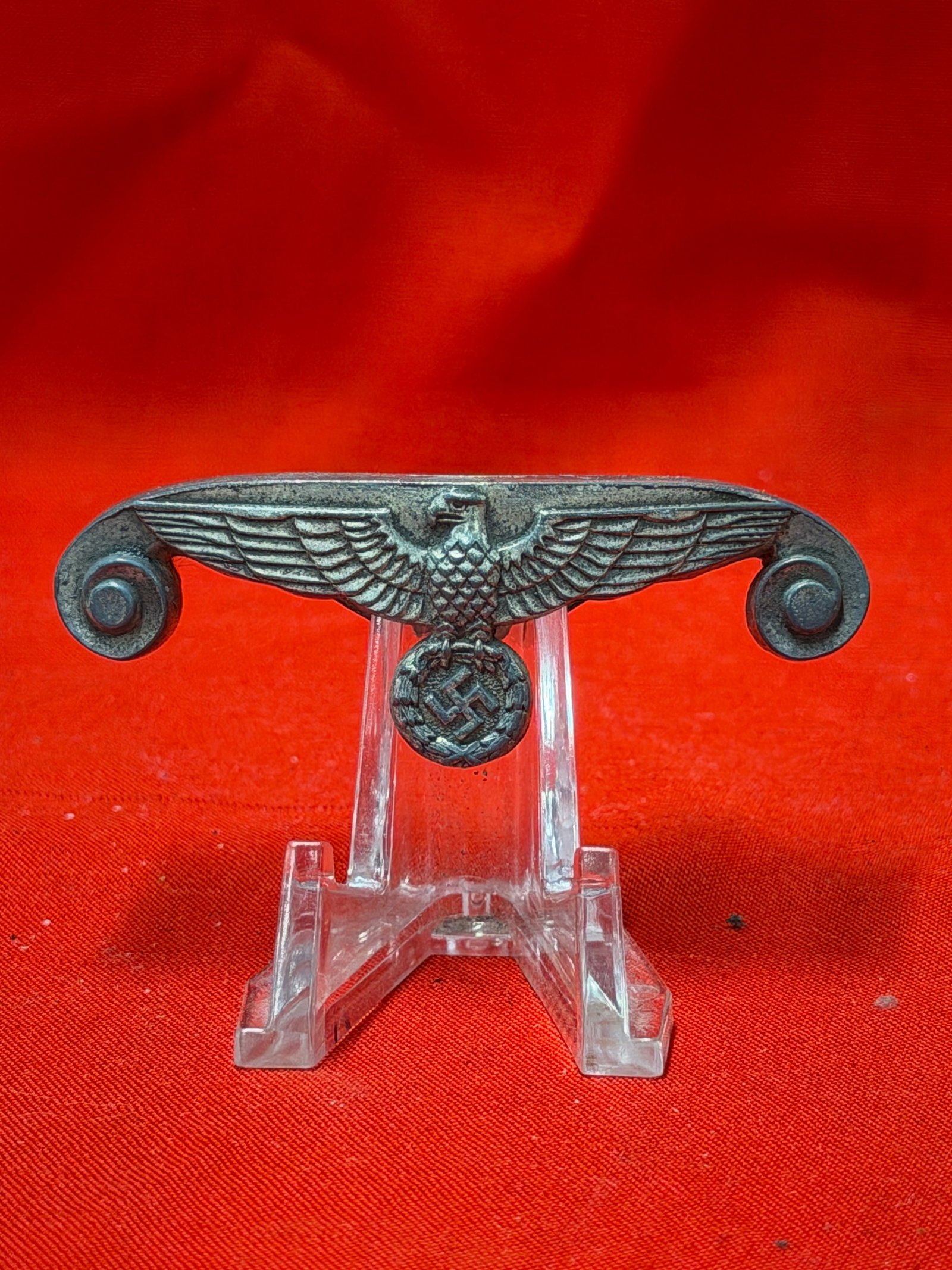 WW2 German Political Eagle Belt Buckle Emblem Attachment: German political eagle emblem attachment featuring spread-wing eagle above circular wreath and lower symbol detail with curved mounting ends on both sides. In our opinion, this piece was designed as a