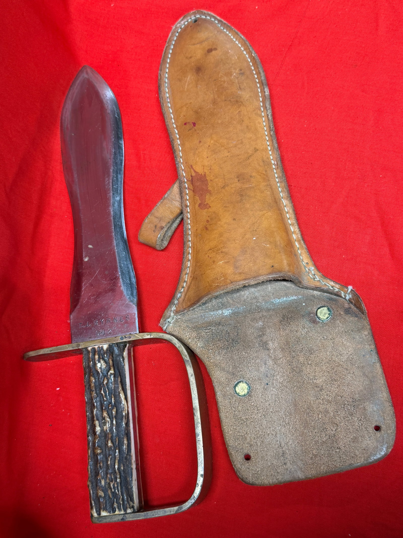 Civil War Era Style Bowie Knife w/ Stag Handle & Leather Sheath – T.J. Byrnes / Barrett Fixed: Large vintage Civil War era style Bowie knife featuring a wide clip-point blade, heavy brass D-guard, stag antler handle, and original brown leather sheath. Blade is marked “T.J. BYRNES O-12” 
