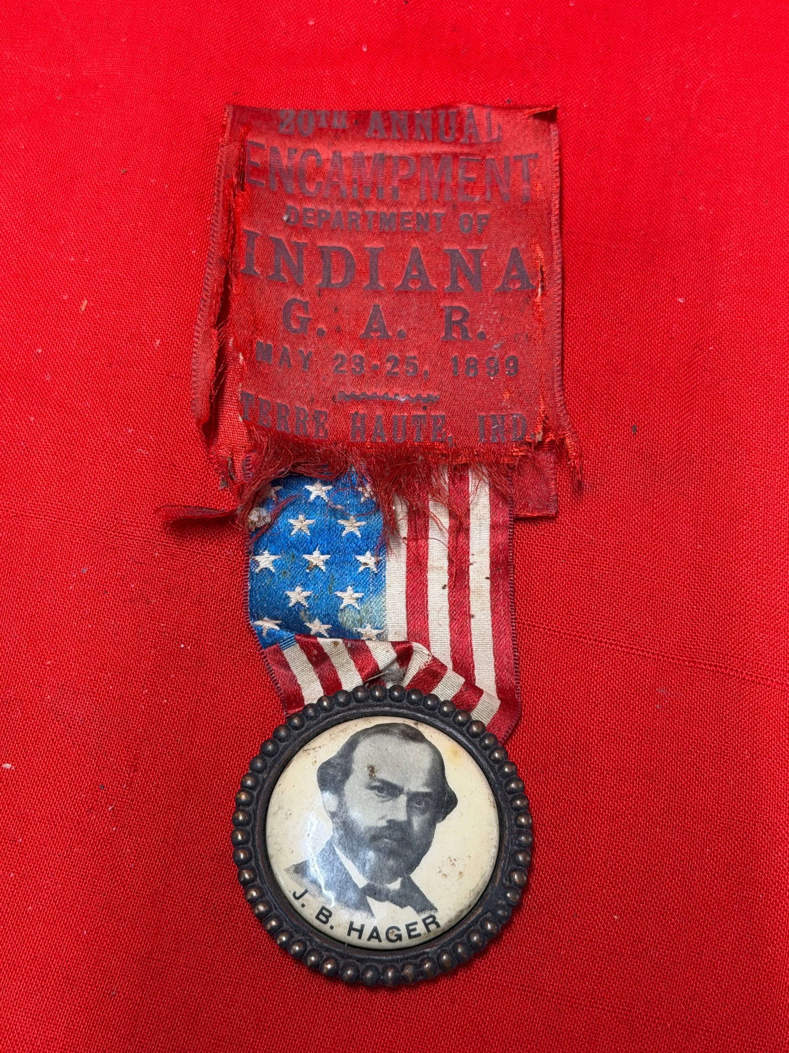 1899 Grand Army of the Republic Indiana Encampment Ribbon Badge Featuring J. B. Hager Portrait –: 19th century Grand Army of the Republic (G.A.R.) reunion or encampment ribbon badge from the 20th Annual Encampment, Department of Indiana, held in Terre Haute, Indiana, May 23–25, 1899. The red sil