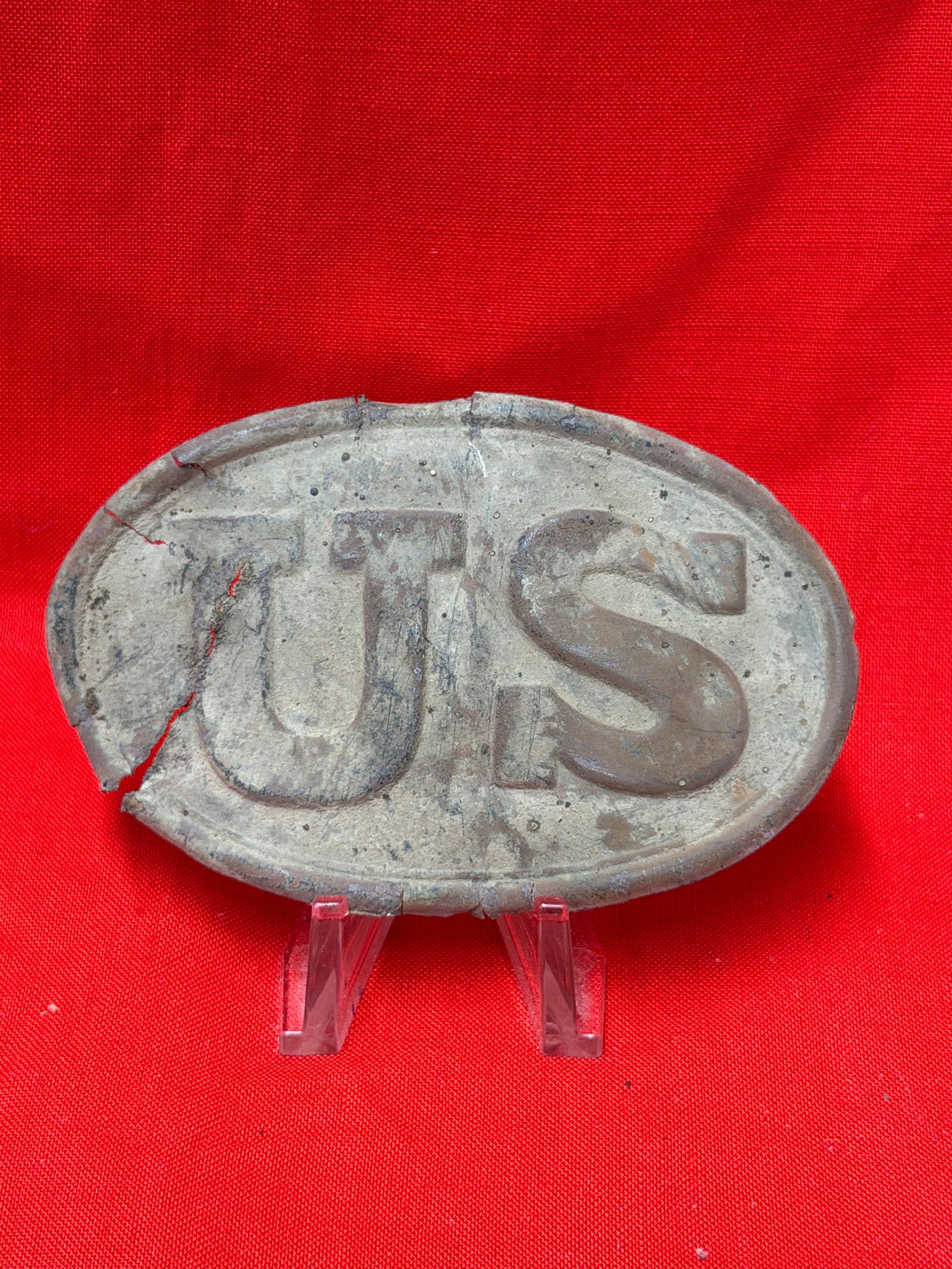 Civil War Era U.S. Cartridge Box Plate Excavated Relic Fragment: Oval U.S. cartridge box plate relic with heavy ground wear and visible cracking throughout. In our opinion this piece is a Civil War era excavated cartridge box plate that was recovered in relic condi