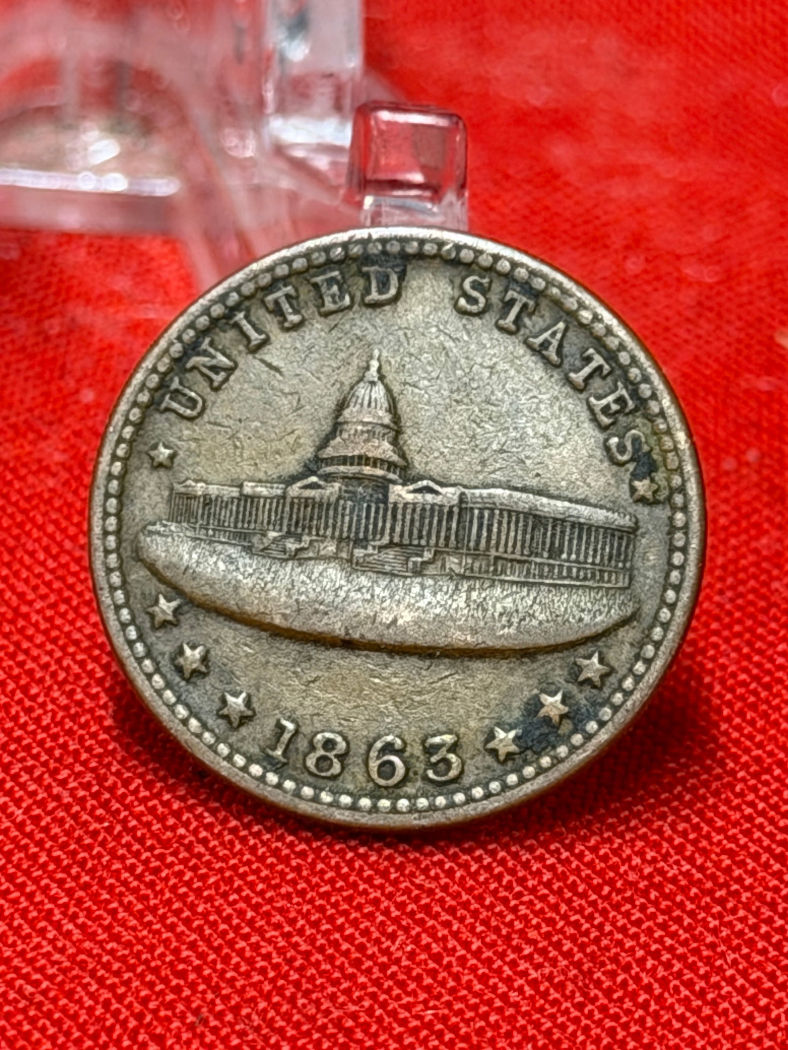 1863 United States Capitol Army & Navy Civil War Token / Patriotic Medal: Civil War-era patriotic token featuring the United States Capitol building with “United States 1863” on the obverse and “Army & Navy” surrounded by a laurel and floral wreath on the re
