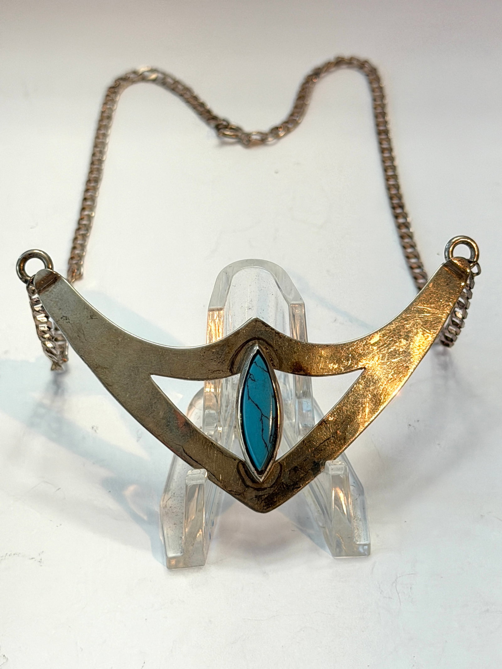 Vintage Sterling Silver Turquoise Modernist Necklace Pendant Southwest Geometric Design: Vintage sterling silver modernist necklace featuring a striking geometric V-shaped pendant with a marquise-cut turquoise stone centerpiece. Sleek mid-century Southwest styling with clean angular lines