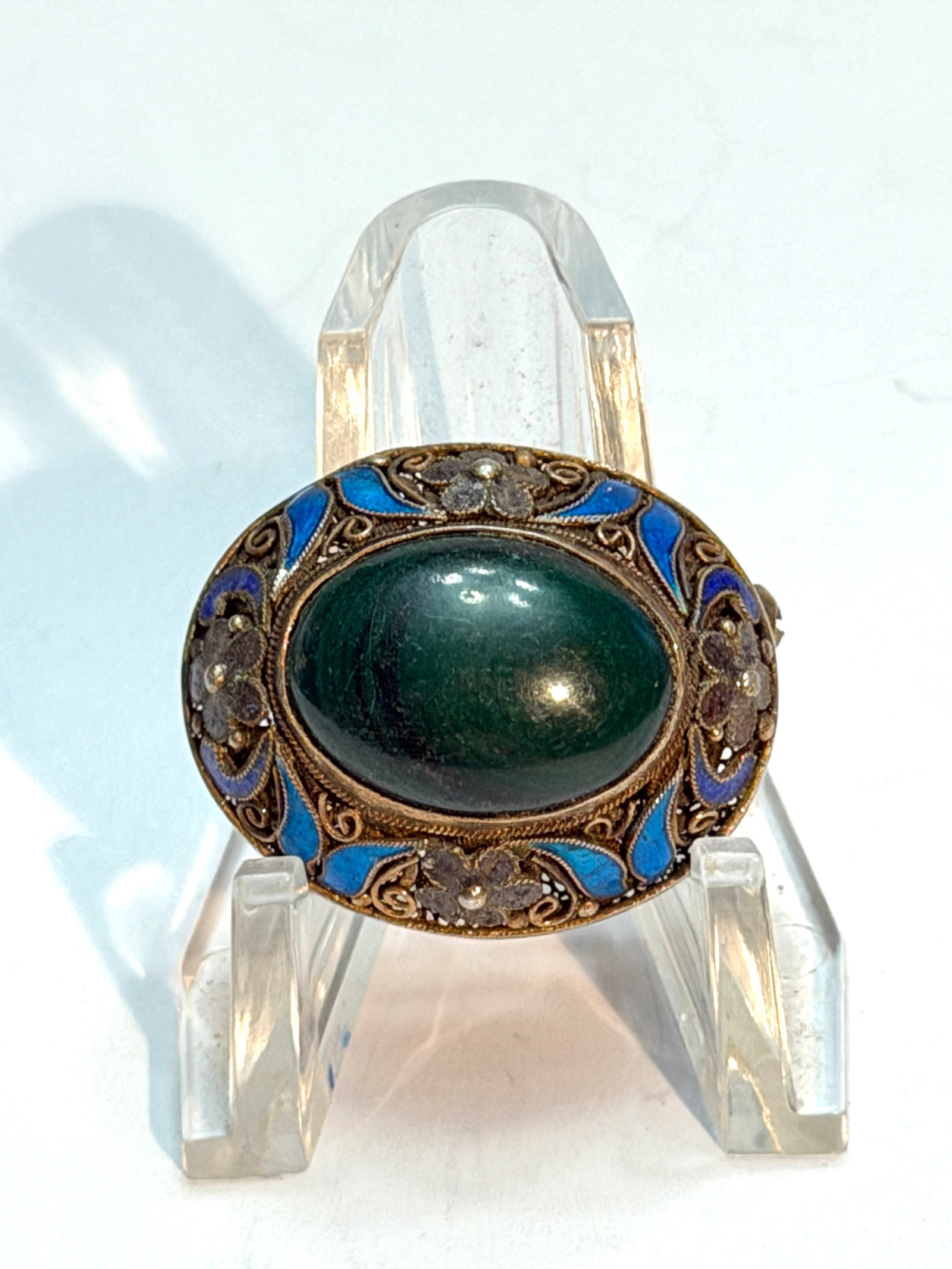 Vintage Sterling Silver Filigree Enamel Brooch Green Cabochon Pin: Beautiful vintage sterling silver brooch featuring an oval deep green cabochon stone surrounded by intricate filigree metalwork with vibrant blue enamel accents and floral detailing. This elegant oval
