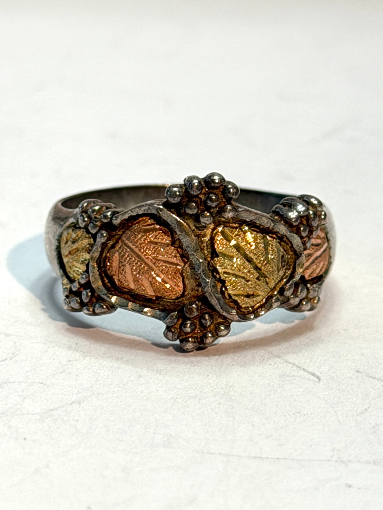 Black Hills Gold Sterling Silver Ring ? 12K Gold Leaf Accents ? Size 12: Black Hills Gold style ring crafted in sterling silver with distinctive rose and yellow gold leaf accents. Features the classic grapevine and leaf motif associated with Black Hills Gold jewelry, accen
