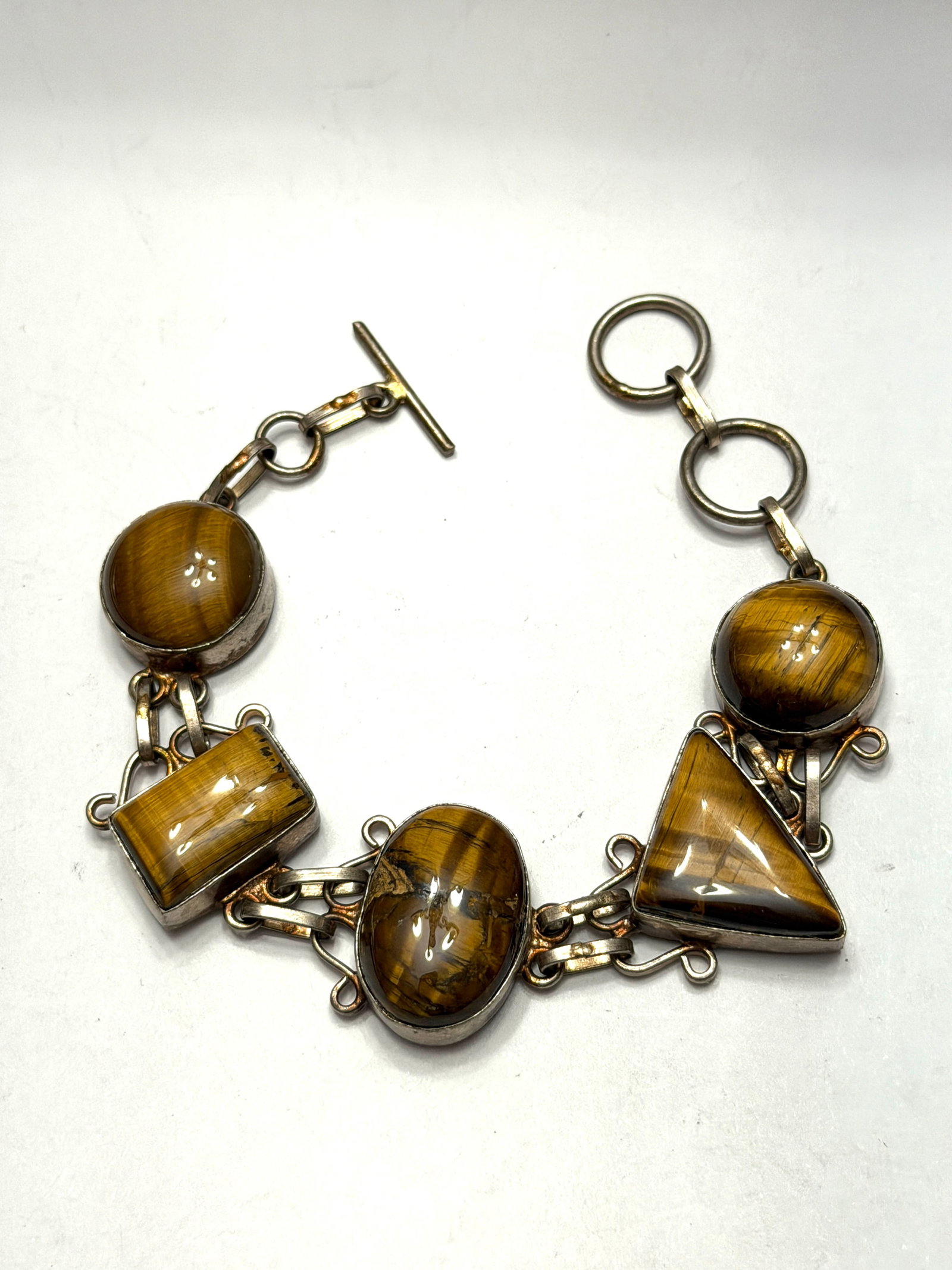 Sterling Silver Tiger?s Eye Bracelet Artisan Gemstone Link Bracelet: Beautiful vintage sterling silver bracelet featuring genuine tiger’s eye gemstones in assorted geometric cuts including oval, rectangular, triangular, and round cabochons. Handcrafted artisan li