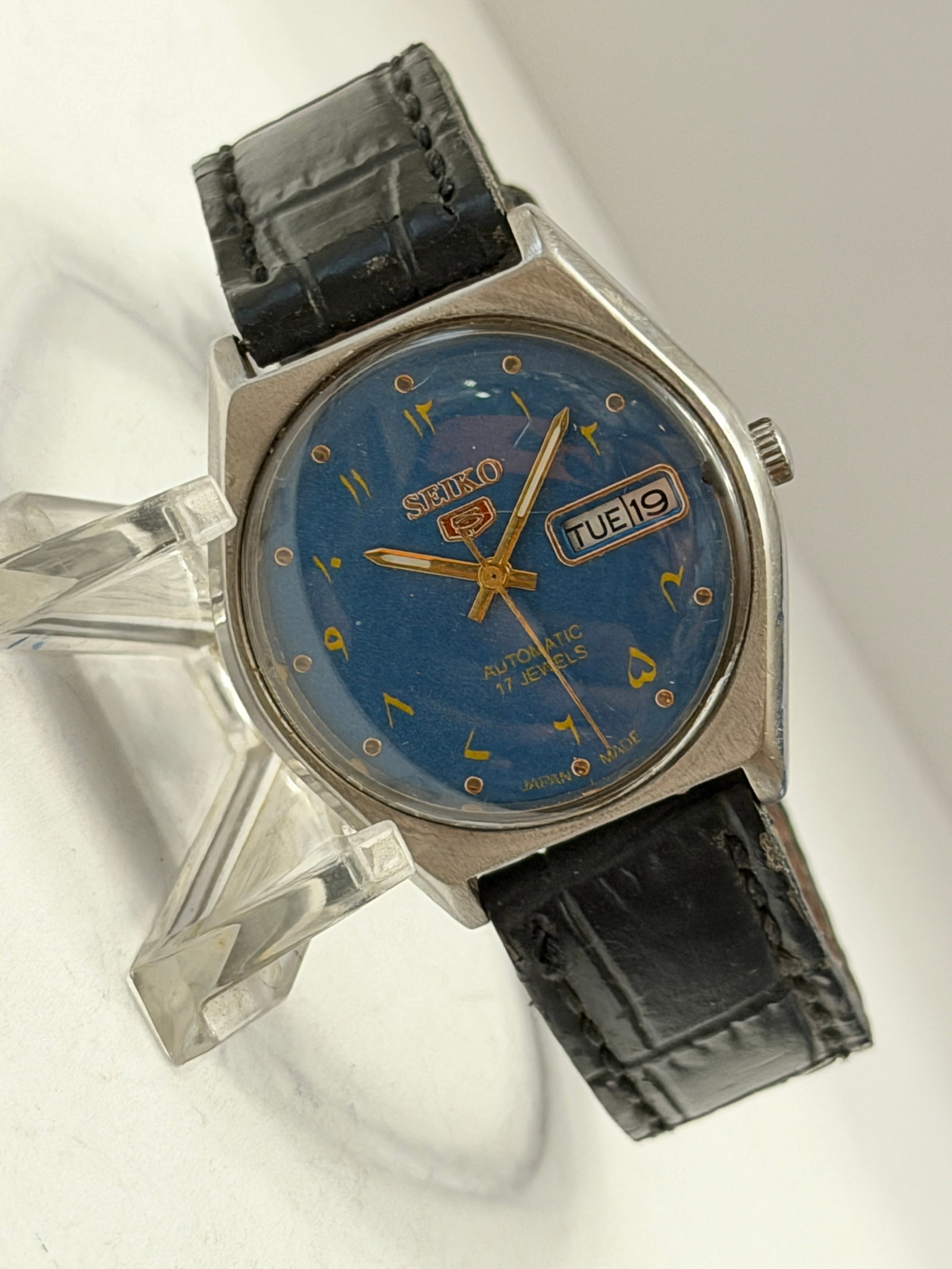 Vintage Seiko 5 Automatic 17 Jewel Blue Dial Day-Date Men?s Watch Japan Made: Vintage Seiko 5 Automatic Day-Date wristwatch featuring a striking deep blue dial with gold-tone Arabic numeral markers and matching gold-tone hands. Powered by a 17 jewel automatic movement, this cla