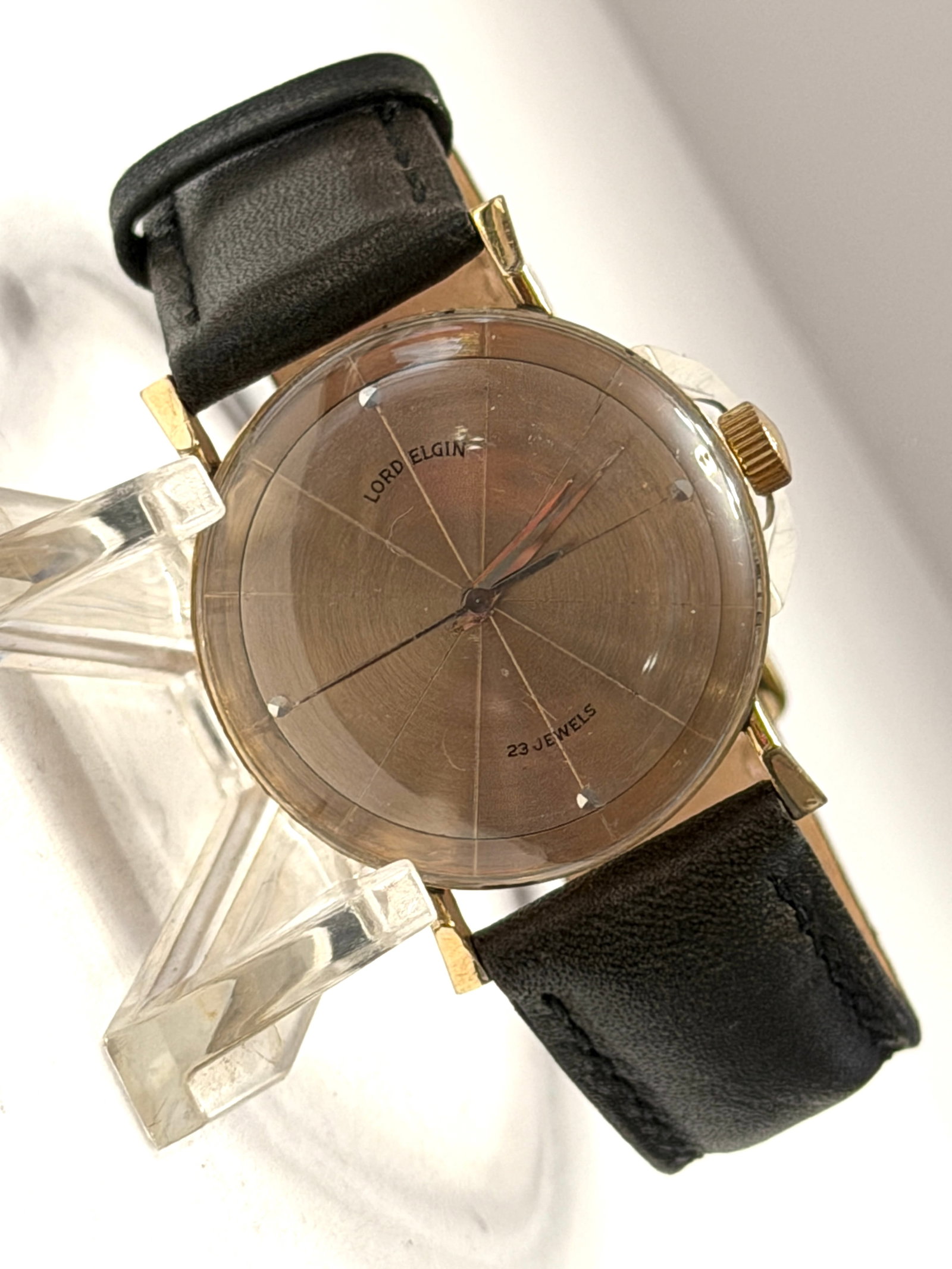 Vintage Lord Elgin 23 Jewels Minimalist Gold Tone Dress Watch: Vintage Lord Elgin 23 Jewels wristwatch featuring a unique minimalist dial design with a warm bronze sunburst finish and geometric line markers extending across the dial. The elegant gold-tone case an