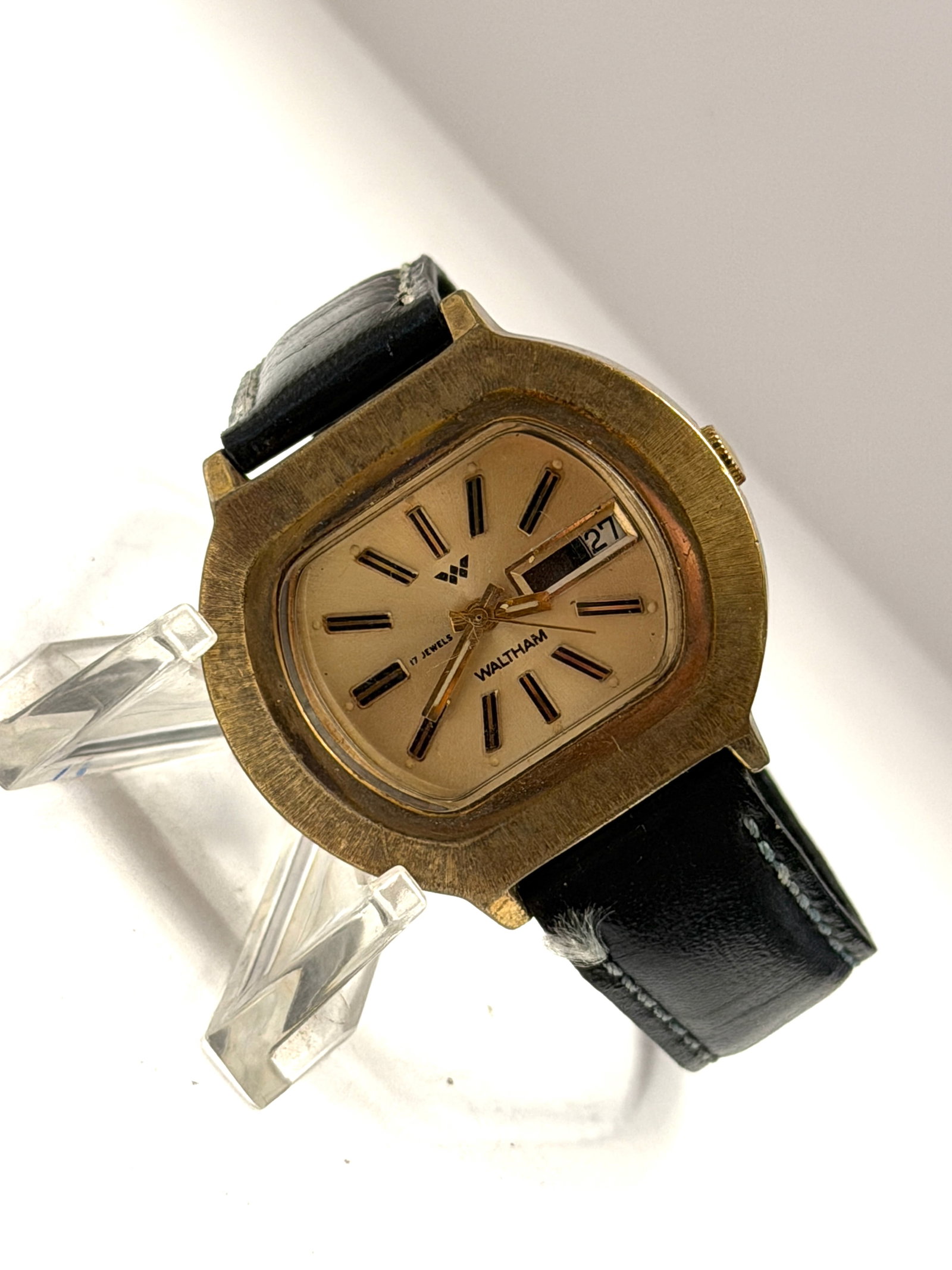 Waltham 17 Jewels Day-Date Cushion Case Men?s Wristwatch: Classic vintage Waltham men’s wristwatch featuring a distinctive cushion-shaped gold-tone case with a warm champagne dial and bold applied hour markers. Powered by a 17-jewel mechanical movement