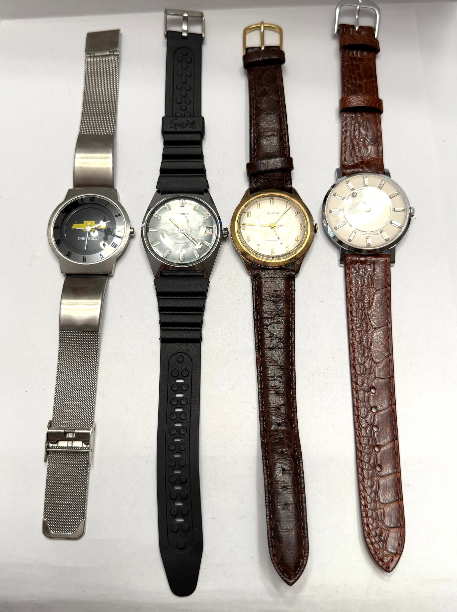 Vintage Watch Lot ? Chevrolet, Cardinal, Bulova & Louvic De Luxe Wristwatches: Collection of four vintage wristwatches featuring a mix of dress and promotional styles from various eras. Included in this lot is a Chevrolet logo watch with stainless mesh bracelet and Roman numeral