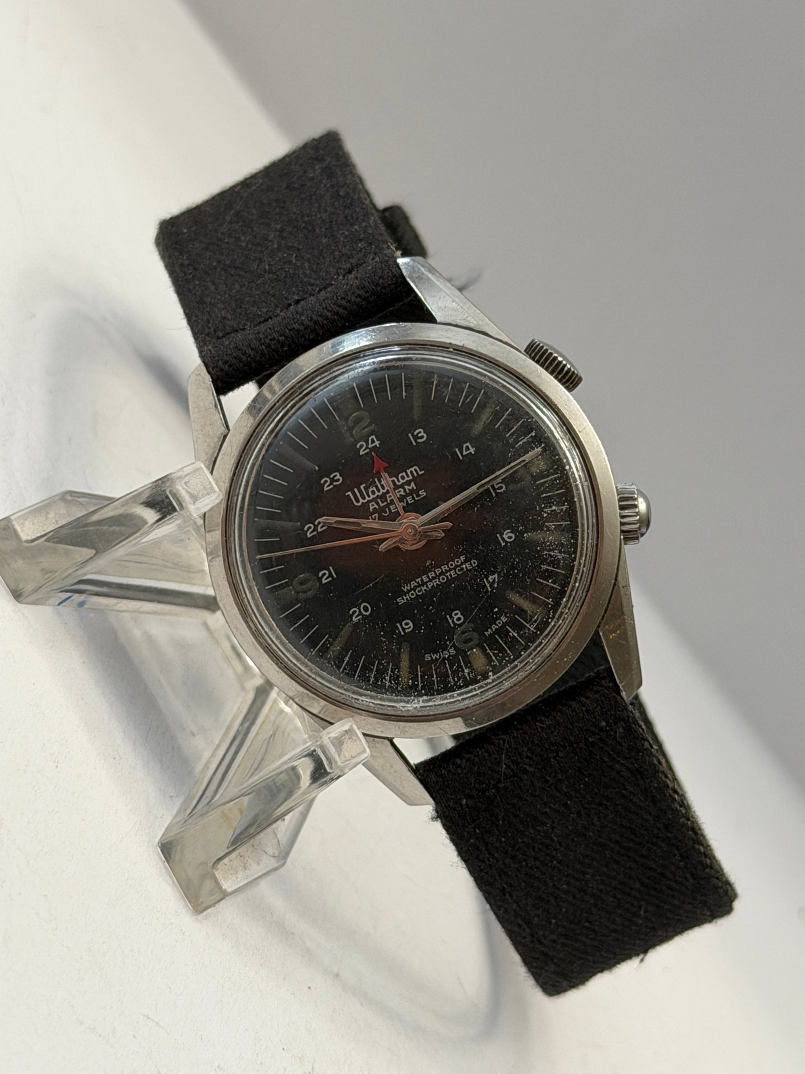 Vintage Waltham Alarm 17 Jewels Wristwatch ? Black Dial: Vintage Waltham Alarm wristwatch featuring a black dial with inner 24-hour military-style markings, luminous hour markers, and central red alarm indicator hand. Dial signed “Waltham Alarm 17 Jew