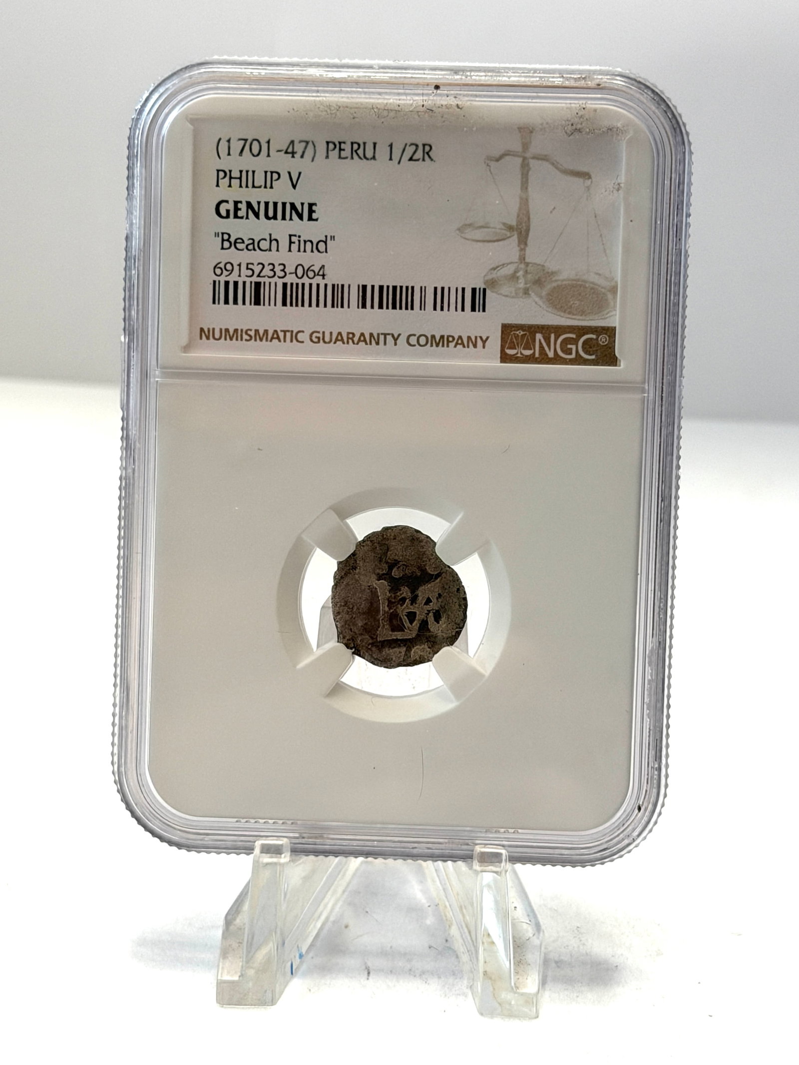 1701-1747 Peru 1/2 Real Philip V NGC Genuine ?Beach Find? Colonial Cob Coin: Authentic Spanish Colonial Peru 1/2 Real cob coin struck during the reign of King Philip V between 1701-1747 and professionally authenticated by NGC as Genuine “Beach Find.” A fascinating 