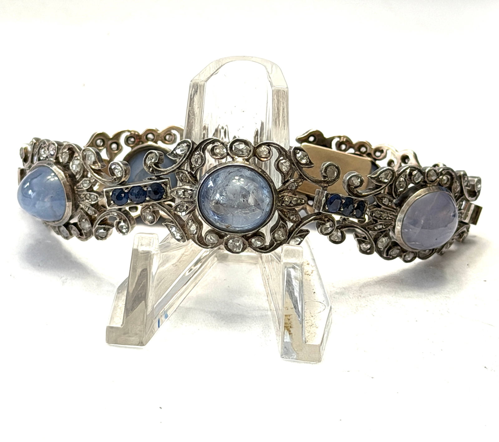 Victorian 14K White Gold Star Sapphire, Sapphire & Mine Cut Diamond Bracelet: Exceptional late Victorian to early Edwardian 14K white gold bracelet featuring an elaborate openwork scroll design set with approximately 50+ carats total weight of luminous cabochon star sapphires, 