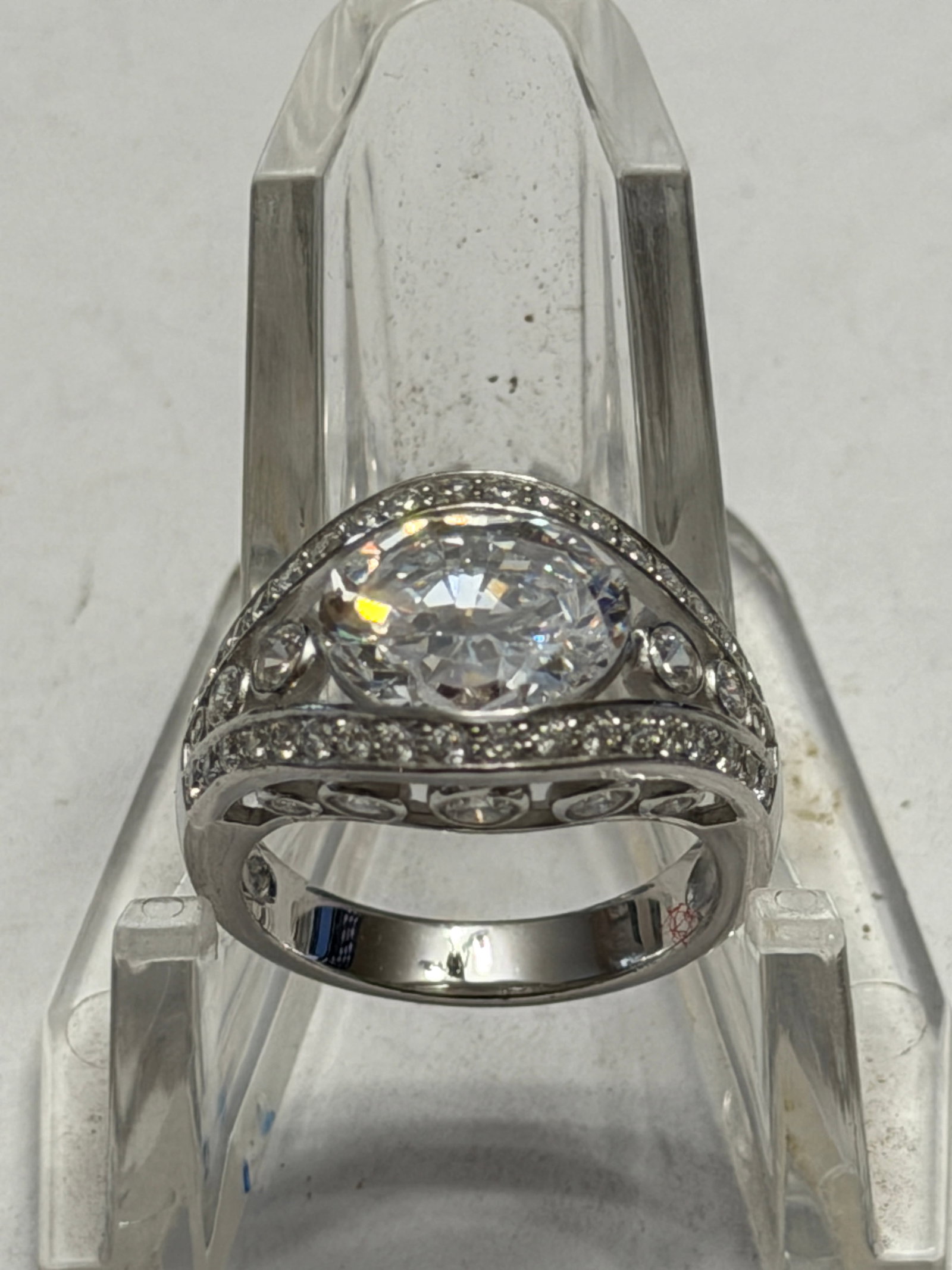 Sterling Silver CZ Swirl Halo Statement Ring Size 7: Elegant sterling silver statement ring featuring a large oval-cut clear cubic zirconia center stone surrounded by sweeping pavé-set accent stones in a modern swirl crossover design. The openwork 