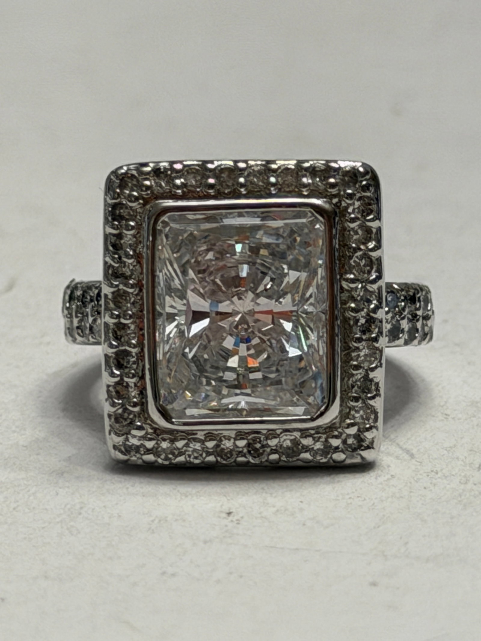 Emerald Cut Halo Cocktail Ring ? Sterling Silver CZ Statement Ring ? Size 5: Striking sterling silver cocktail ring featuring a large emerald-cut clear center stone framed by a halo of small pavé-style accent stones. Additional accent stones continue along the shoulders o