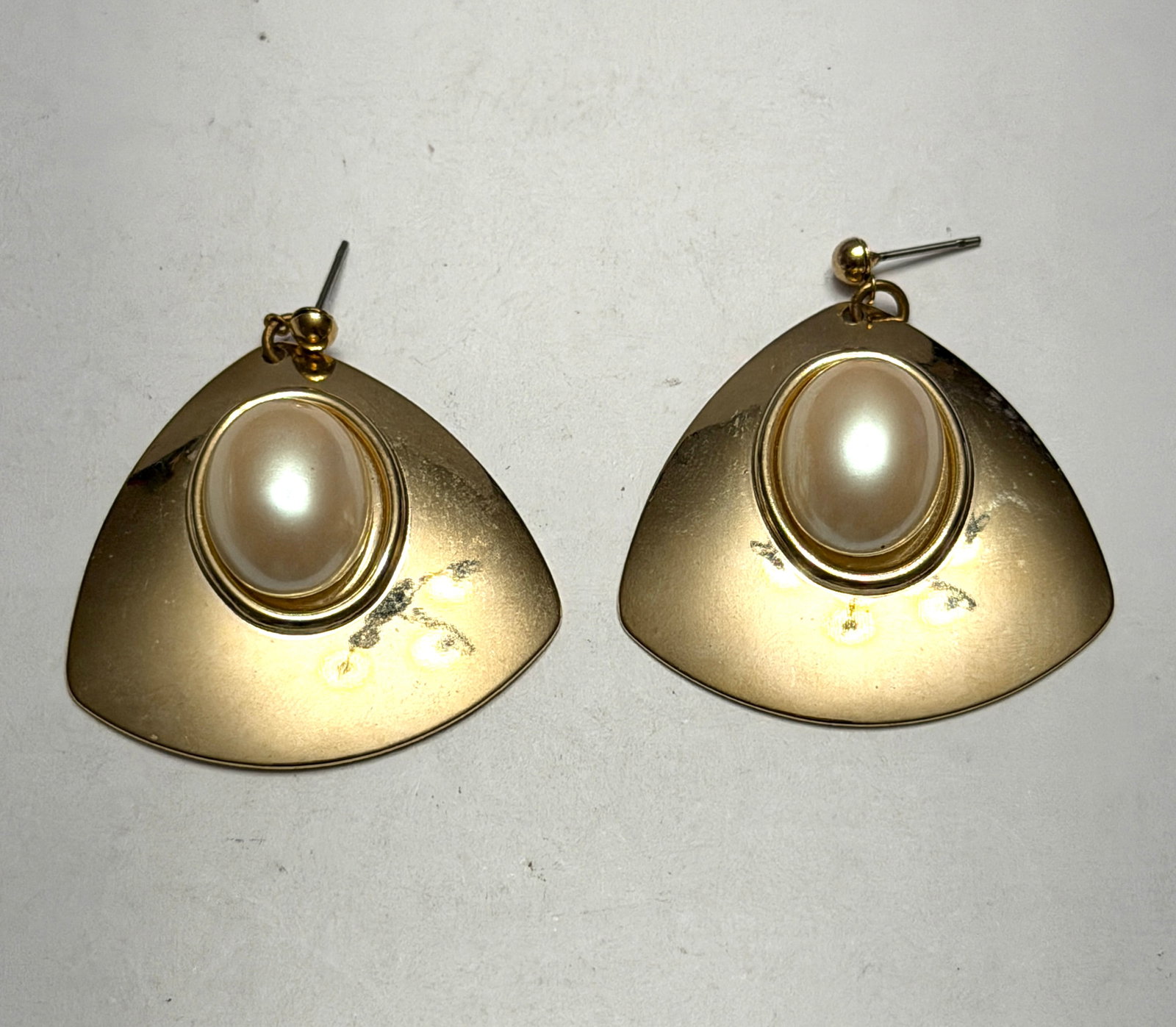Vintage Gold Tone Faux Pearl Statement Drop Earrings Unmarked: Stylish vintage gold tone statement earrings featuring bold geometric fan shaped drops accented with large oval faux pearl cabochons at the center for an elegant retro look. These eye-catching earring
