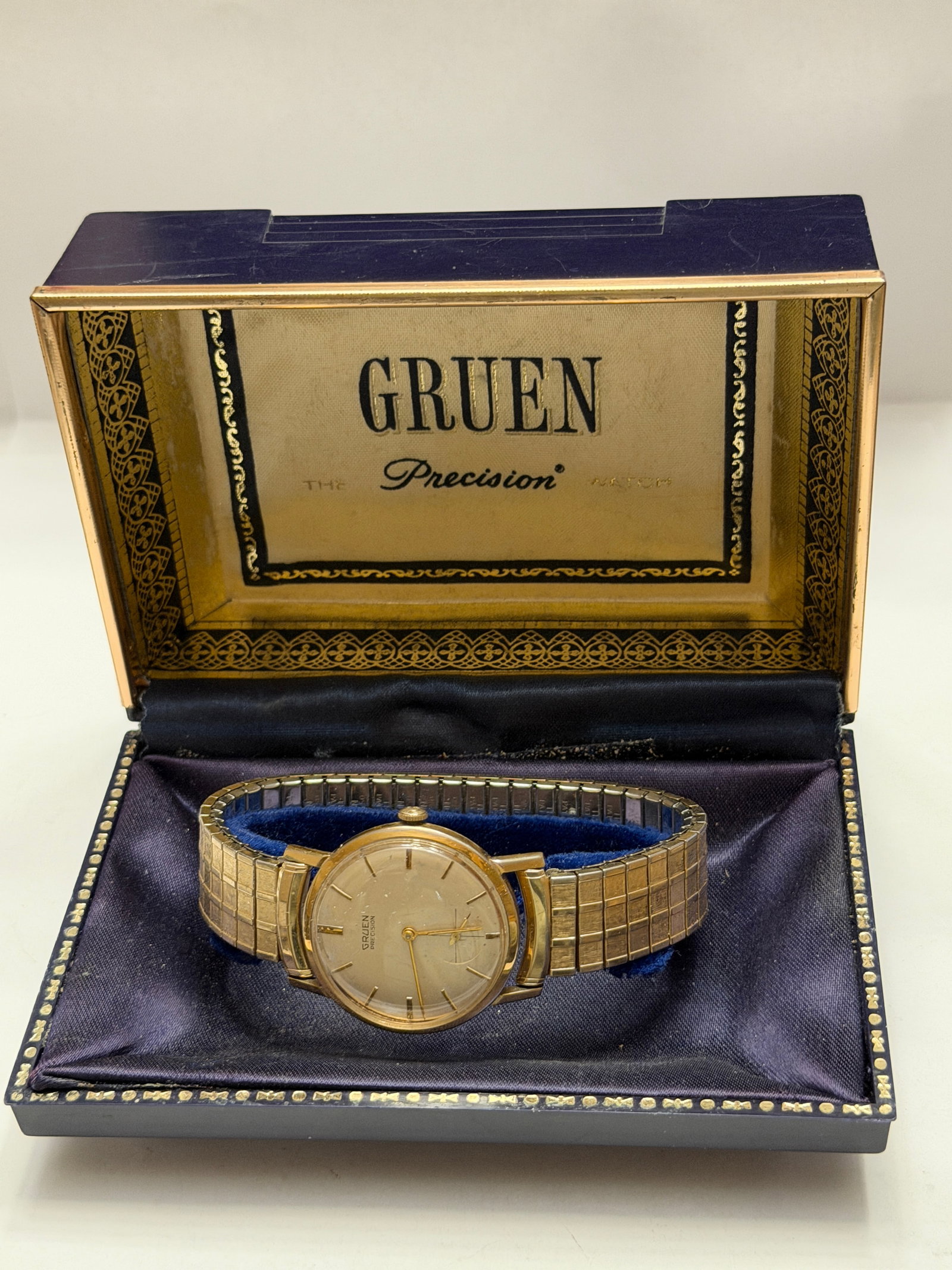 Vintage Gruen Precision Gold-Tone Manual Wind Wristwatch with Original Presentation Box: Vintage Gruen Precision wristwatch featuring a classic gold-tone round case with a minimalist silver-tone dial, applied baton hour markers, and subsidiary seconds register positioned at 6 o’cloc