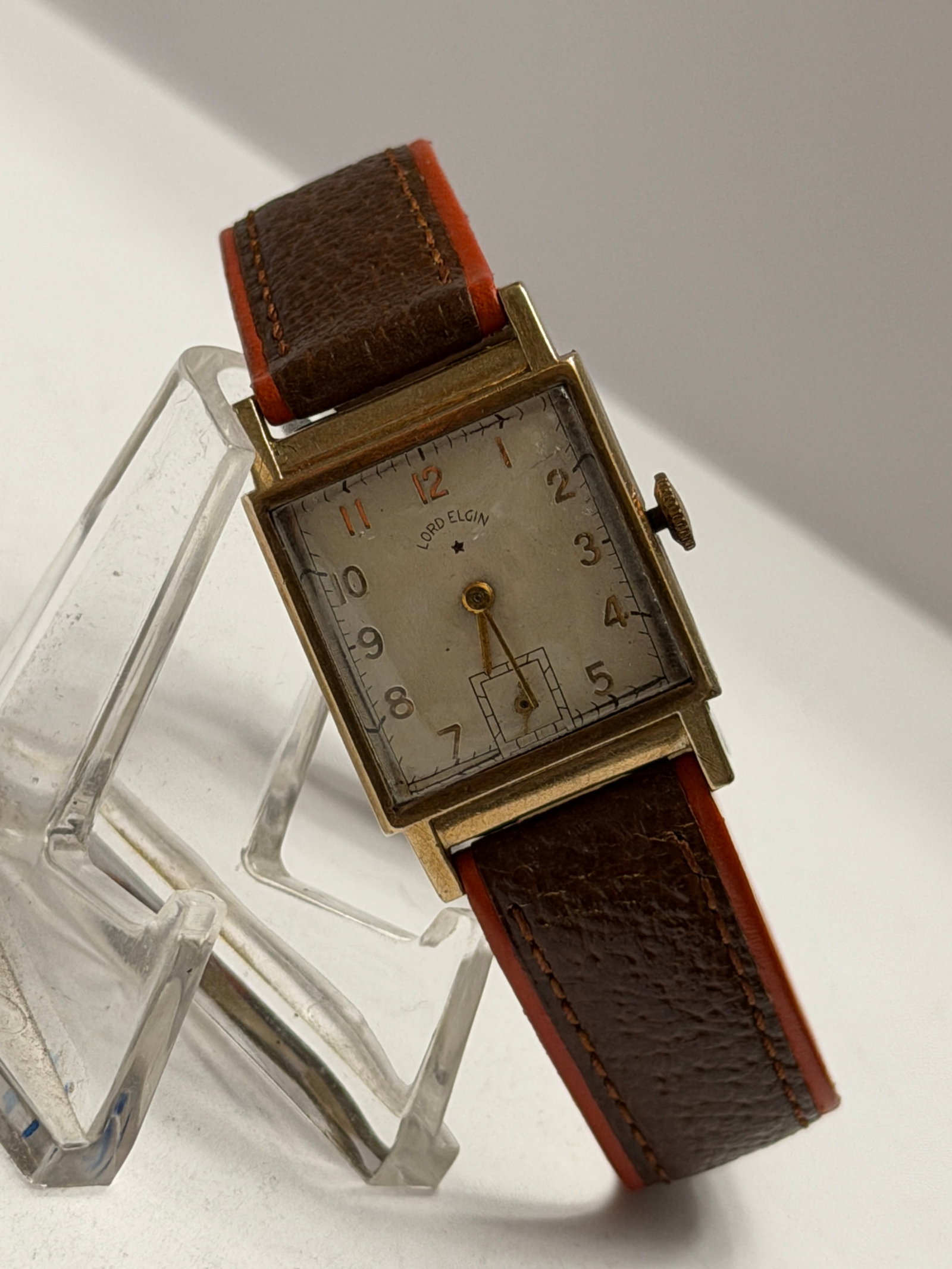 Lord Elgin Rectangular Art Deco Wristwatch ? Gold Tone Case ? Small Seconds ? Manual Wind: Vintage Lord Elgin rectangular wristwatch featuring a classic Art Deco-inspired design with a silver-tone dial, stylized Arabic numerals, and a recessed small seconds subdial above 6 o’clock. Th