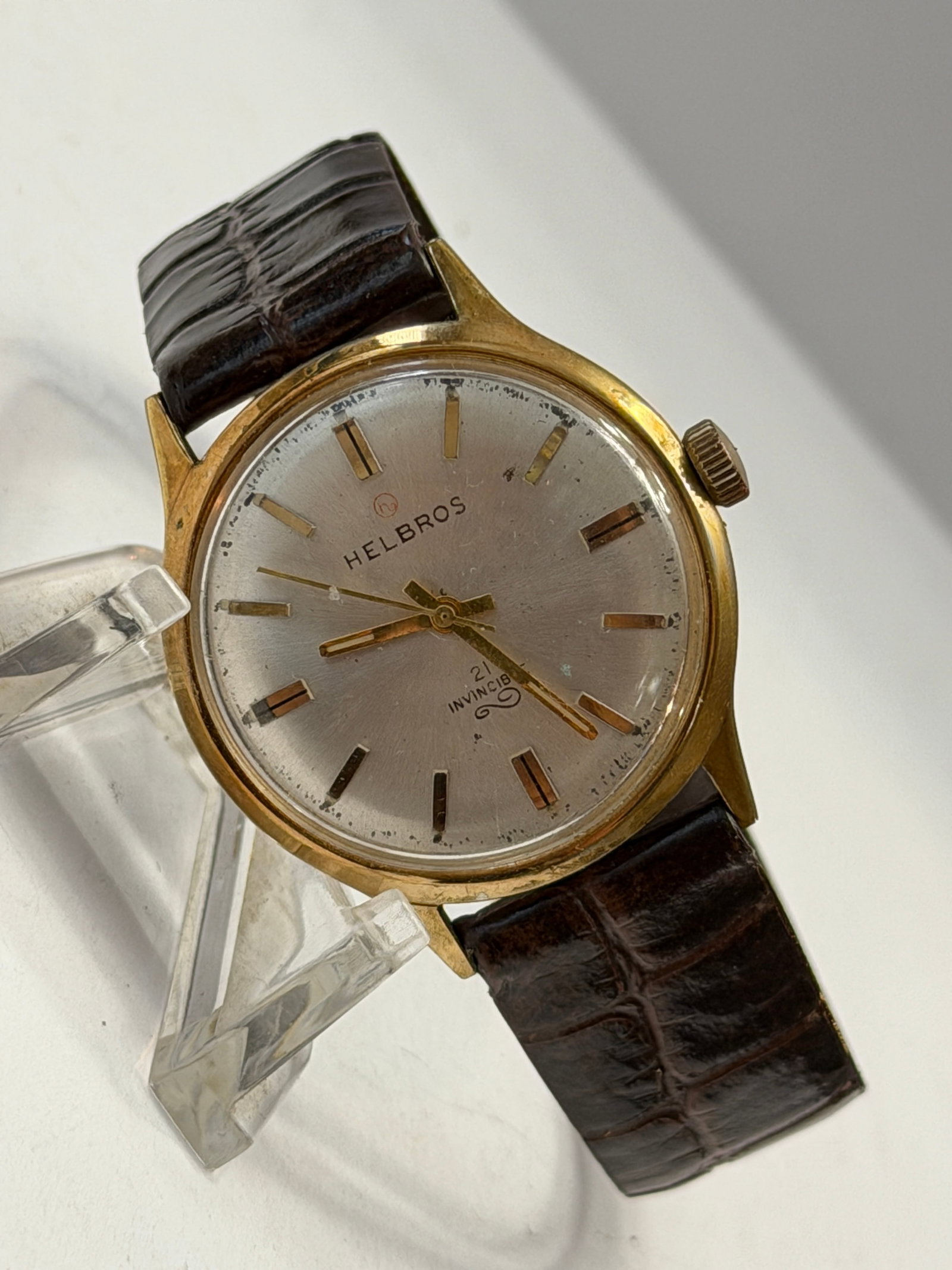 Vintage Helbros Invincible 21 Jewel Dress Watch ? Gold Tone Case ? Swiss Made Automatic Wristwatch: Vintage Helbros “Invincible” wristwatch featuring a timeless mid-century dress watch design with a silver sunburst dial, gold-tone applied hour markers, and elegant matching hands housed i