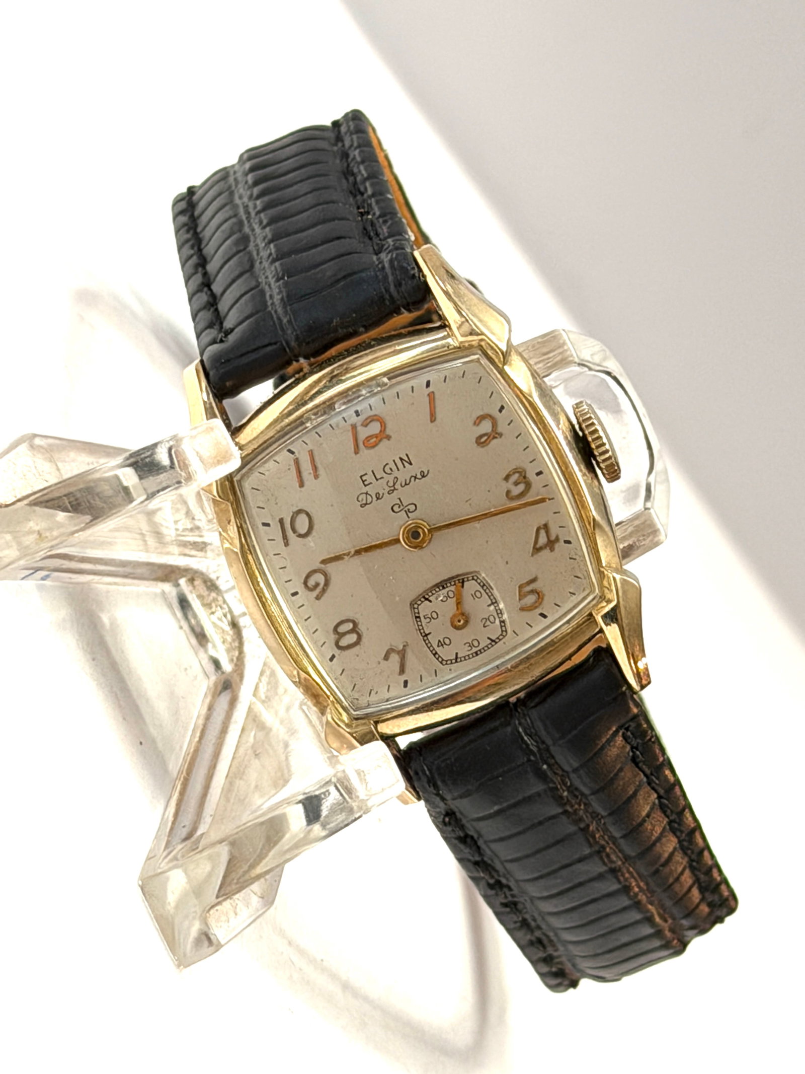Elgin DeLuxe Art Deco Wristwatch ? 10K Gold Filled ? Small Seconds Manual Wind: Classic vintage Elgin DeLuxe wristwatch featuring an elegant Art Deco-inspired tonneau/cushion-shaped case in 10K gold-filled construction. The refined silver-tone dial is accented by warm gilt Arabic