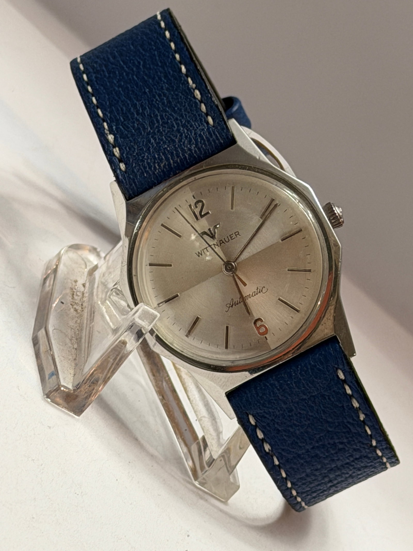 Wittnauer Automatic Stainless Steel Wristwatch Silver Dial Blue Leather Strap: Classic vintage Wittnauer automatic wristwatch featuring a clean mid-century modern design with timeless understated elegance. This handsome automatic watch showcases a silver sunburst dial with appli