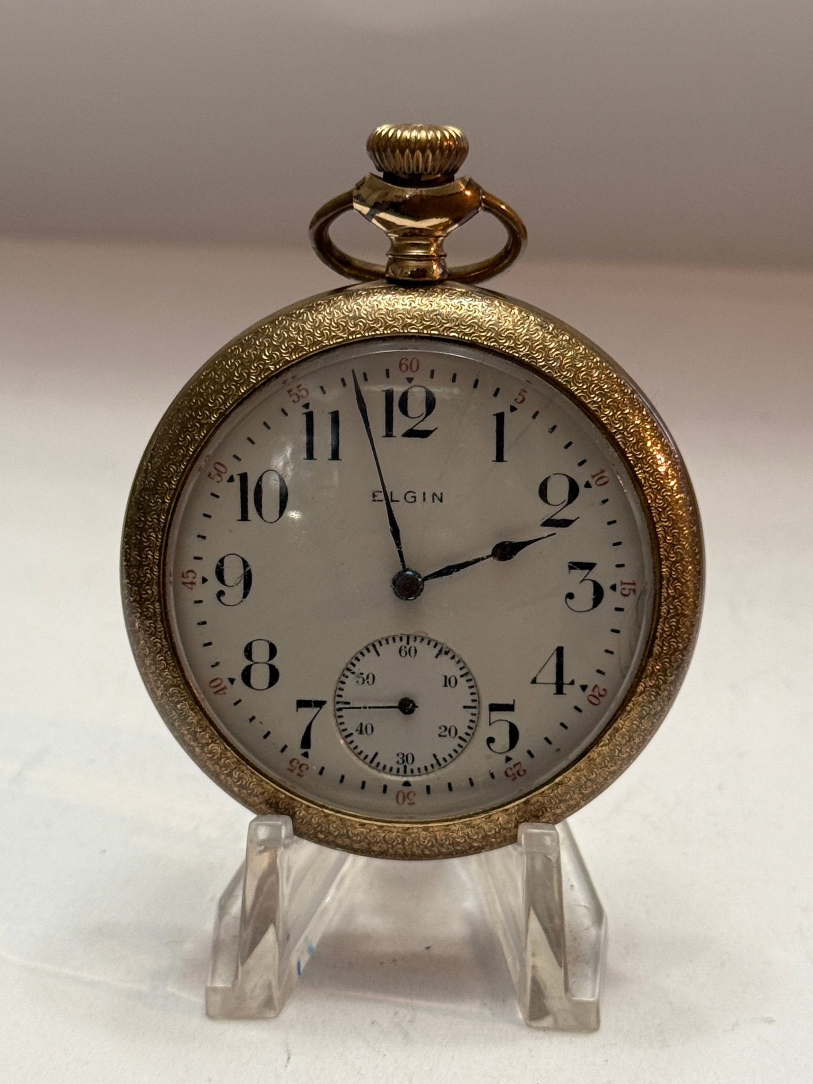 Antique Elgin Pocket Watch with Ornate Gold-Filled Hunter Case: Antique Elgin pocket watch featuring a classic white porcelain dial with bold black Arabic numerals, red outer minute markers, elegant blued steel hands, and a subsidiary seconds dial at the 6 o’