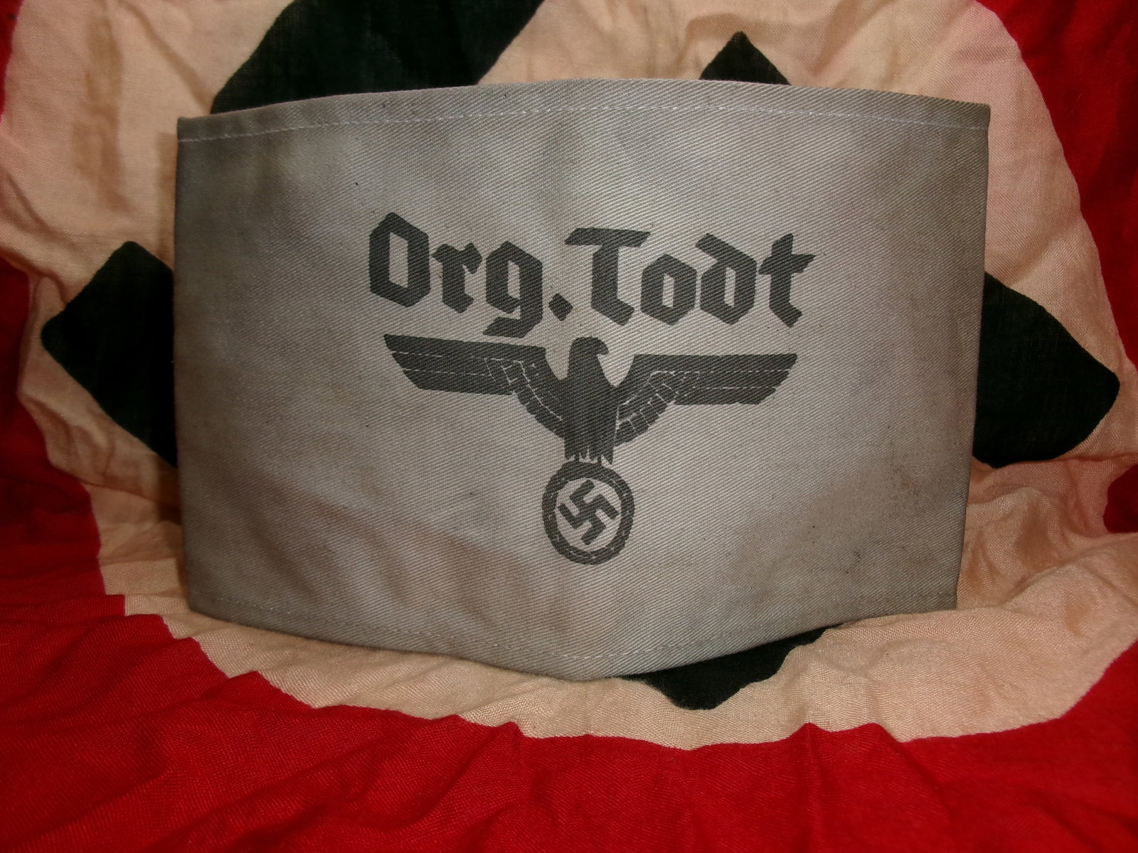 WWII German Organization Todt Administrative Armband With RZM Paper Tag: This gray cloth armband bears the printed inscription “Org. Todt” above a national eagle and swastika emblem, identifying it with Organization Todt, the massive engineering and construction or