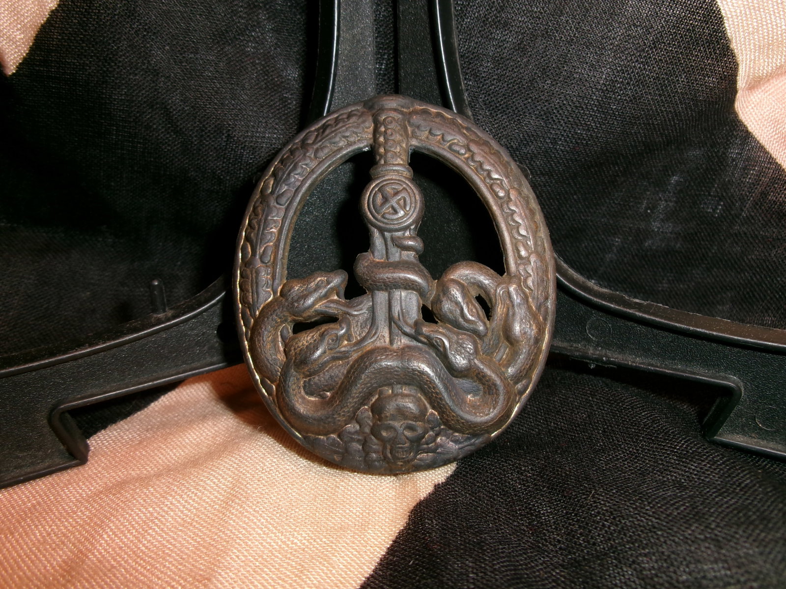 WWII German Anti-Partisan War Badge (Bandenkampfabzeichen): This oval-shaped WWII German combat award is identified as the Anti-Partisan War Badge, also known as the Bandenkampfabzeichen. The badge features a vertically positioned sword entwined by a serpent, 