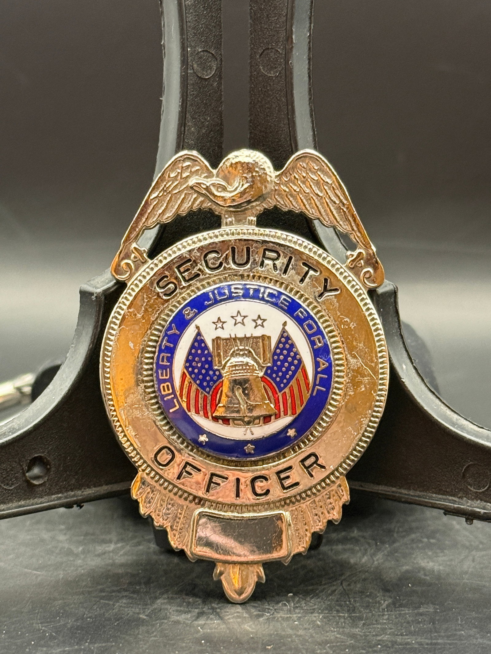 Vintage “Security Officer?? Liberty & Justice Badge: This gold-tone and enamel “Security Officer” badge displays an eagle crest above a circular center seal bearing the Liberty Bell and crossed American flags surrounded by the motto “Liberty &