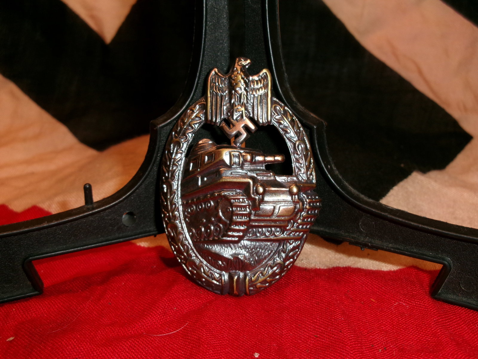 WWII German Panzer Assault Badge: This World War II German Panzer Assault Badge depicts an advancing tank beneath a national eagle and swastika, enclosed within an oak leaf wreath. Instituted in December 1939, the badge recognized arm