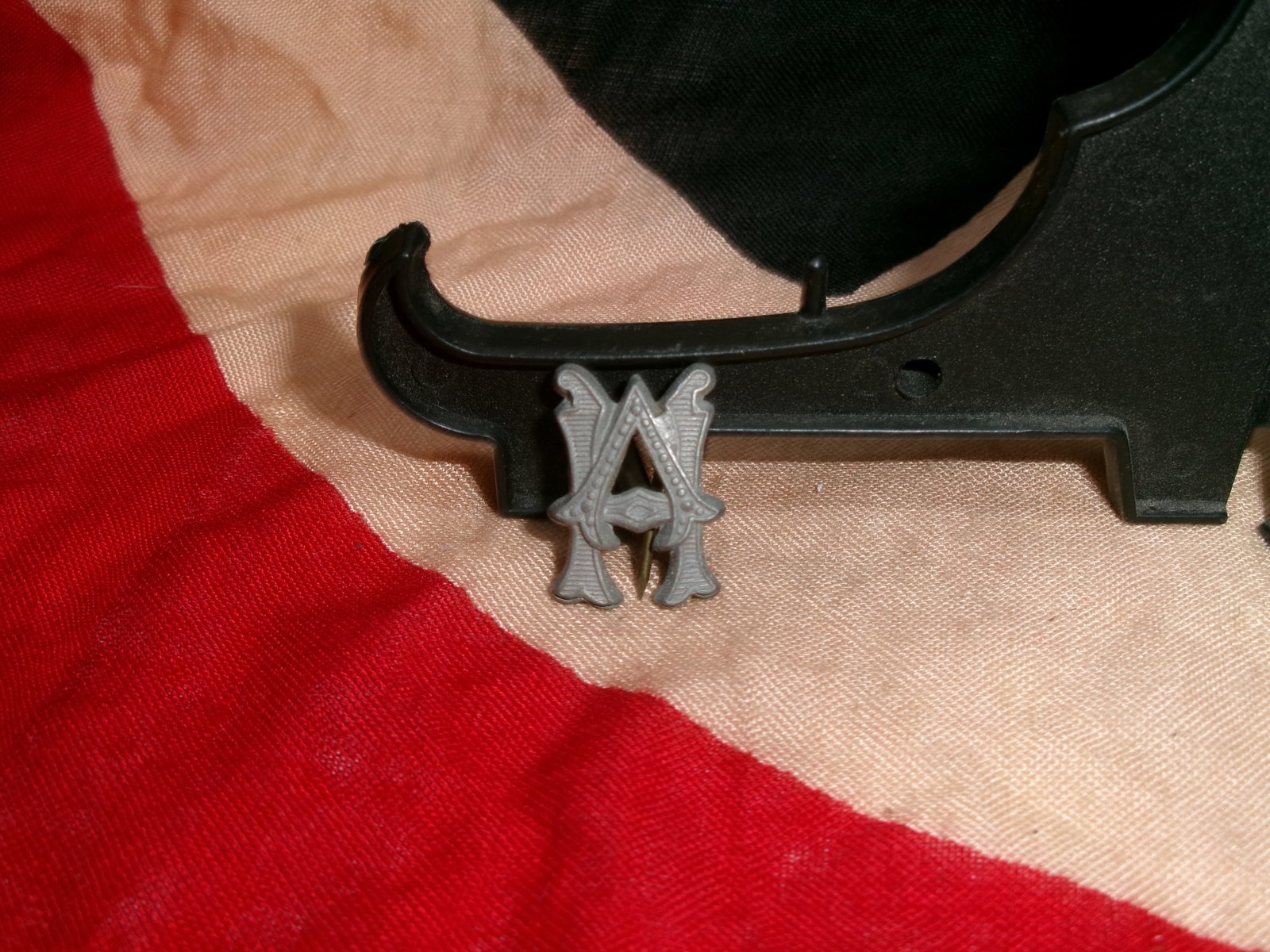 WWII German Heeresverwaltung (HV) Army Administration Uniform Insignia Pin Badge: Offered here is a German Heeresverwaltung (HV) Army Administration insignia featuring the distinctive intertwined “HV” monogram design. Constructed of metal with a dark gray finish, the badge 