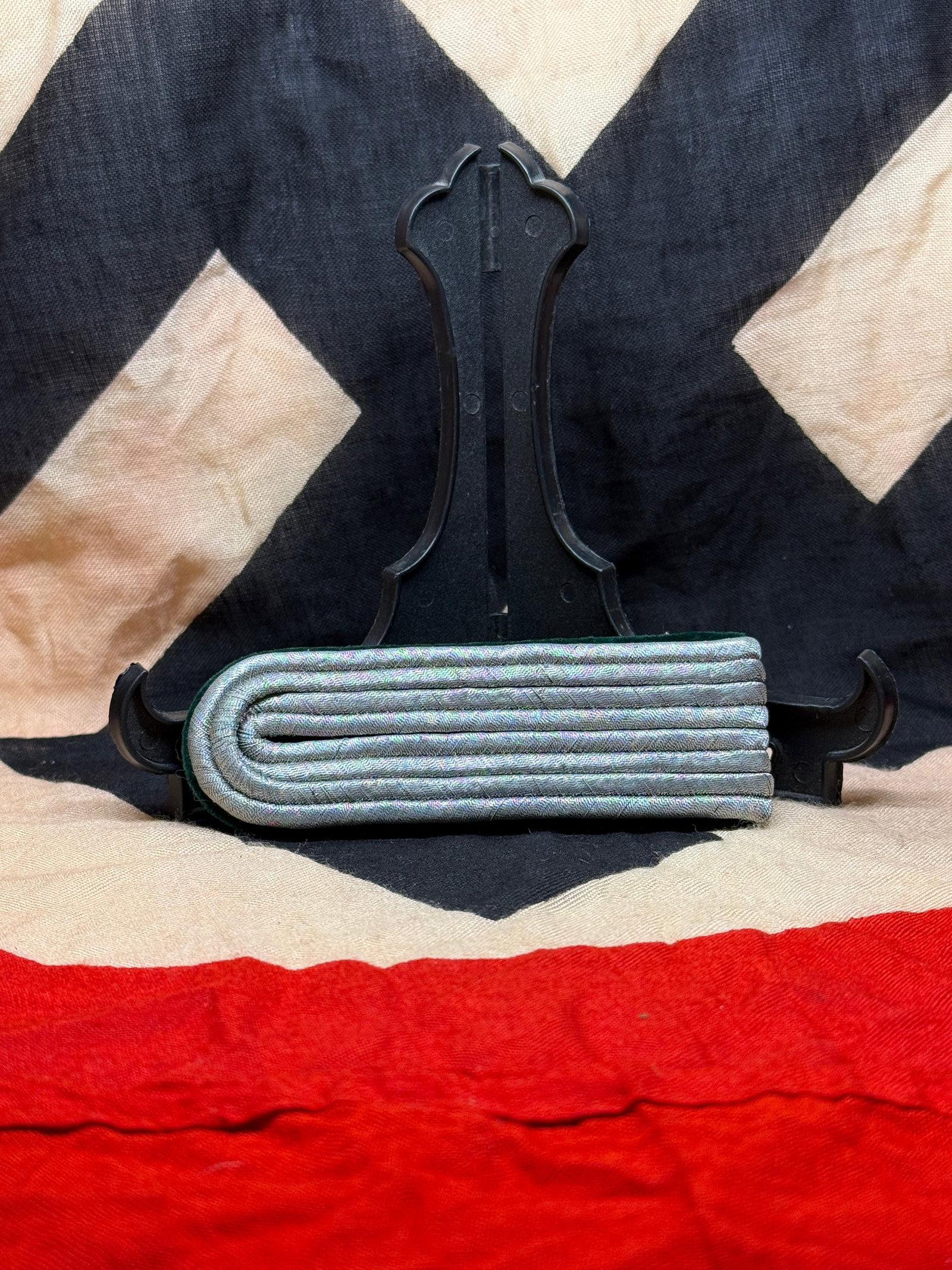 WWII German Heer (Army) Officer’s Shoulder Board: This shoulder board was worn by a commissioned officer of the German Army (Heer) during the Second World War. Constructed from silver-gray Russian braid mounted on a dark green wool backing, it formed