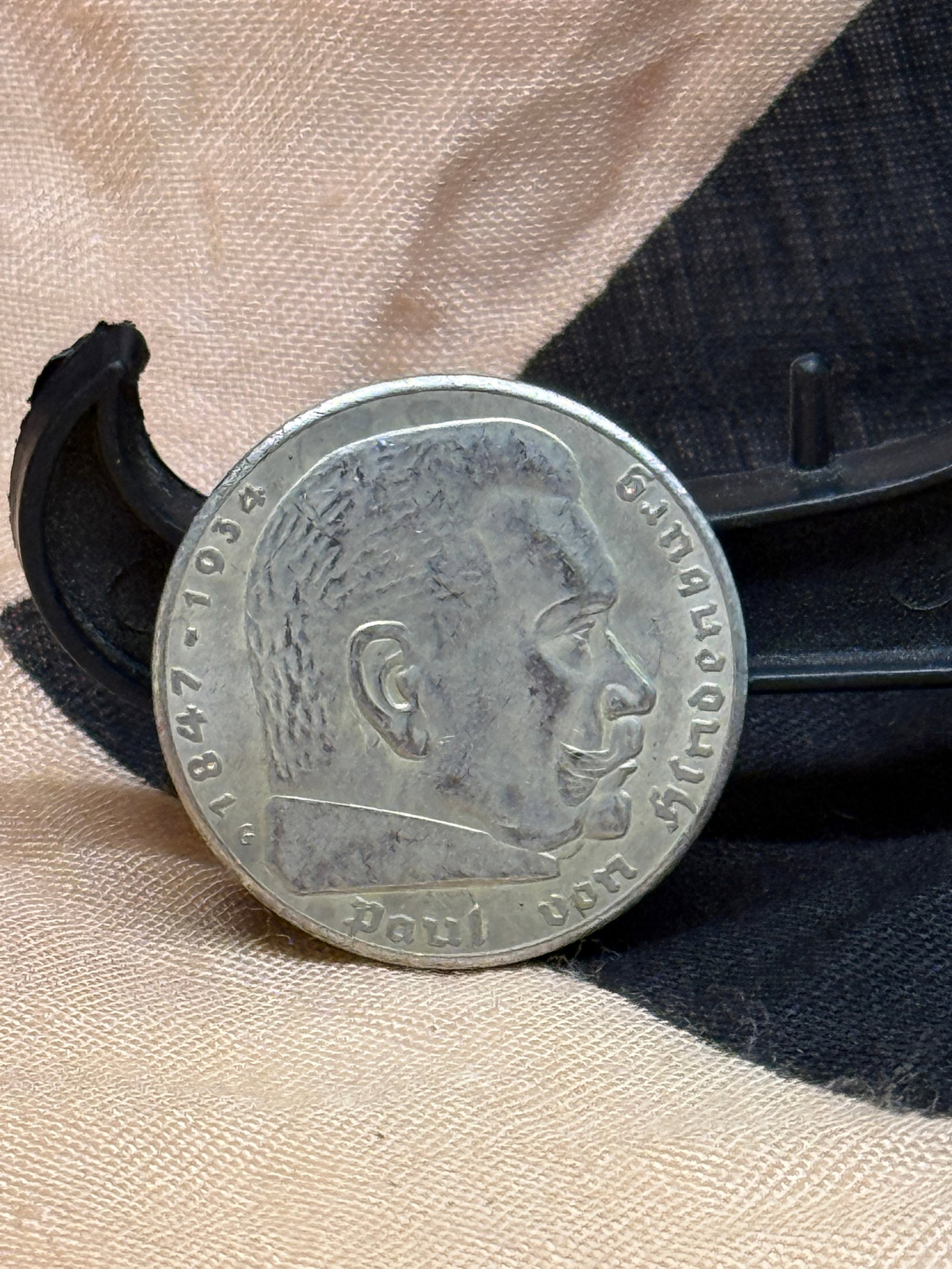 WWII German 5 Reichsmark Silver Coin, Paul von Hindenburg, 1936: This German 5 Reichsmark silver coin features a right-facing portrait of Field Marshal and President Paul von Hindenburg (1847–1934), whose image appeared on several German coin issues during the Th
