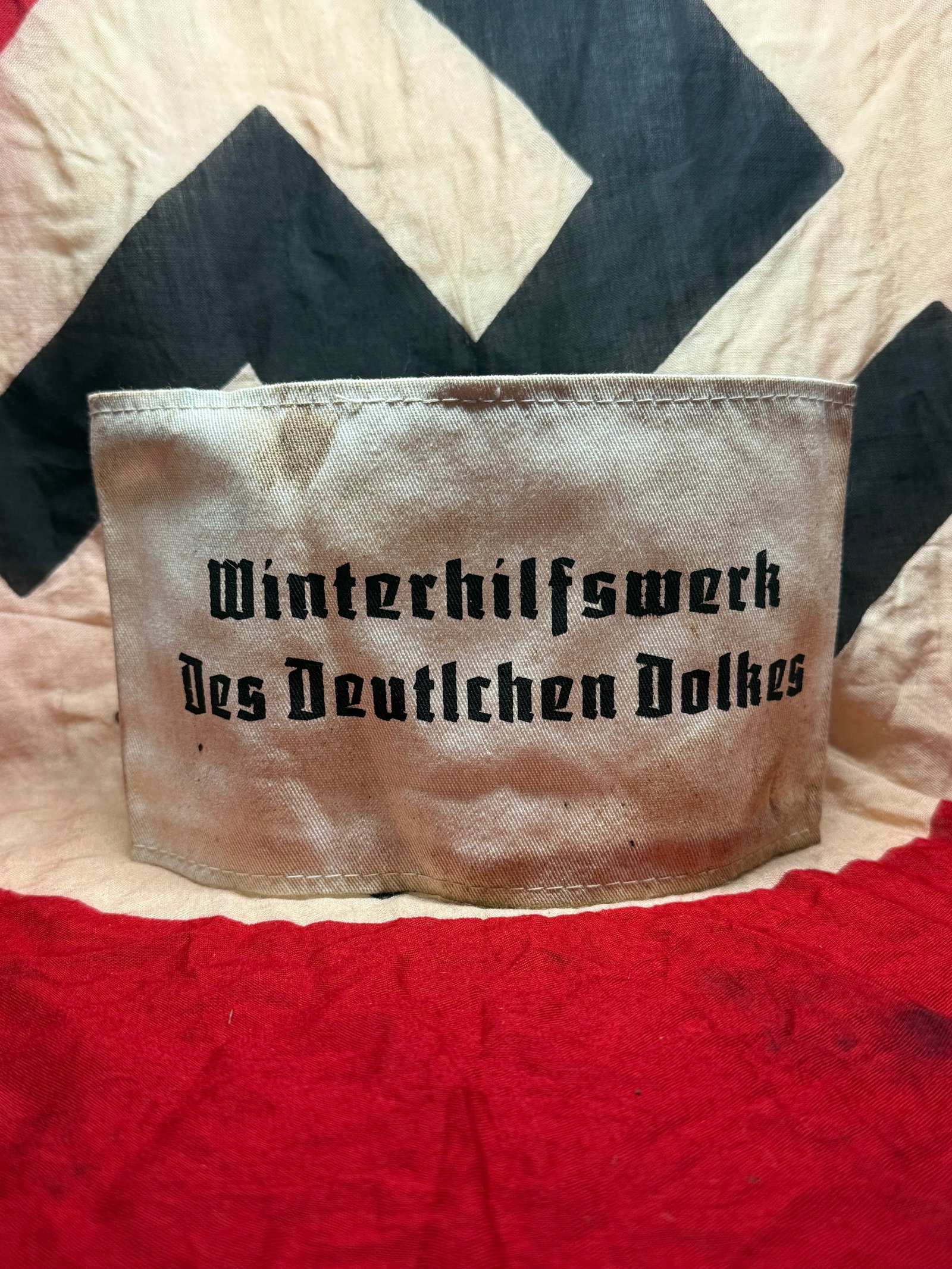 WWII German Winterhilfswerk (WHW) Armband: This cloth armband is identified by the printed inscription “Winterhilfswerk des Deutschen Volkes” (“Winter Relief of the German People”), referring to the nationwide charitable aid or