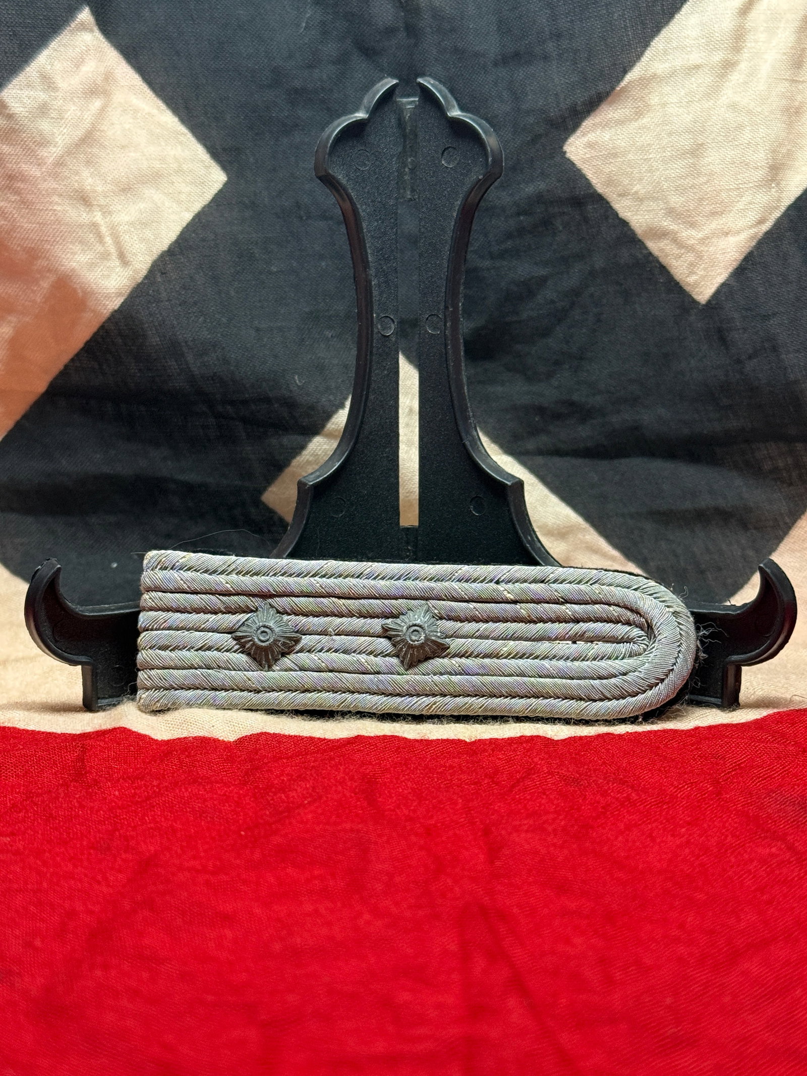 WWII German Army Shoulder Board: This shoulder board consists of silver-gray twisted cord mounted over a dark wool backing and fitted with two rank pips. The design is characteristic of German Army (Heer) uniform insignia used during