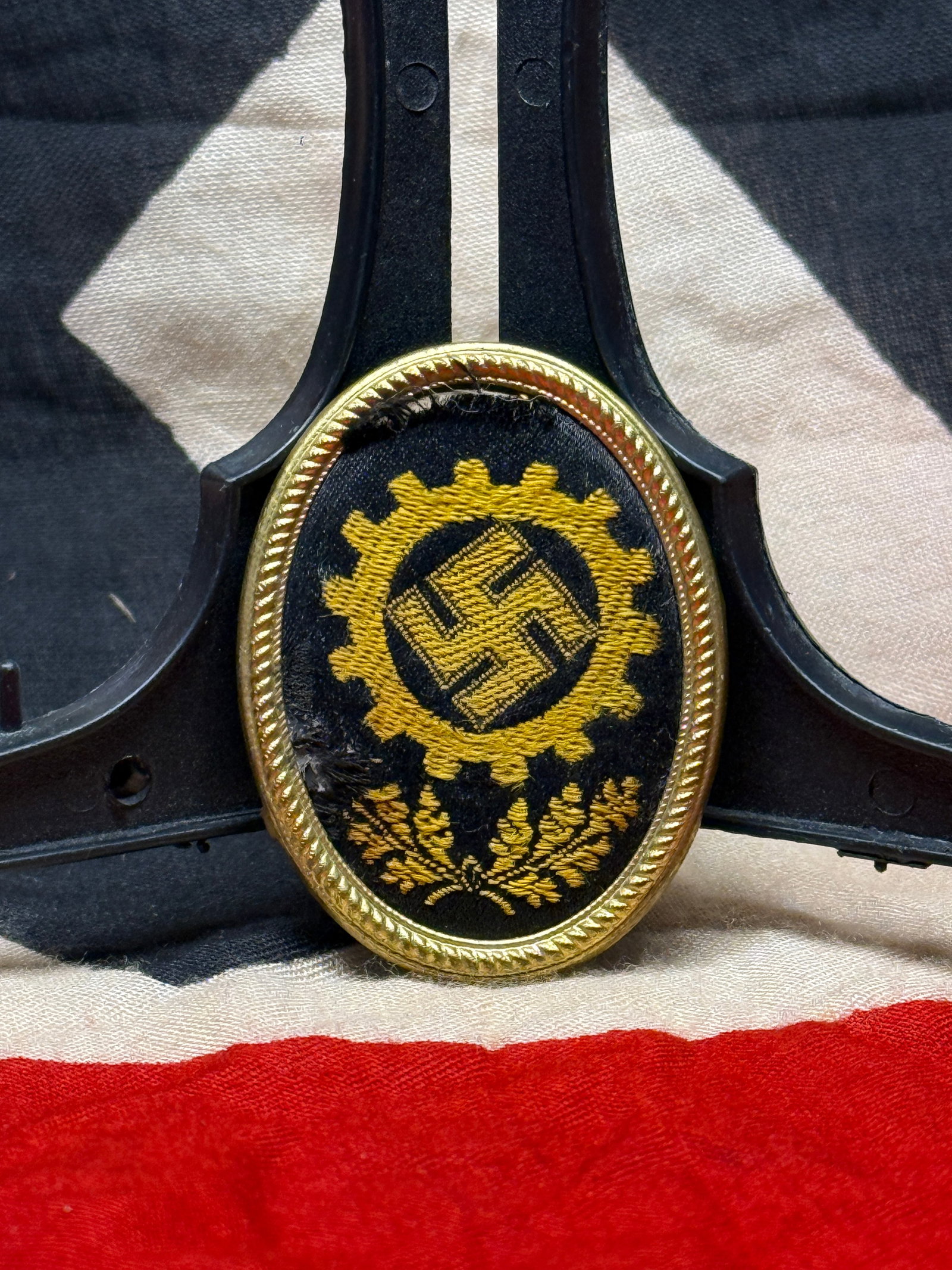 WWII German National Socialist Motor Corps (NSKK) Membership Badge: An oval cloth-and-metal membership badge associated with the National Socialist Motor Corps (NSKK), a motorized paramilitary organization active in Germany before and during World War II. The embroide