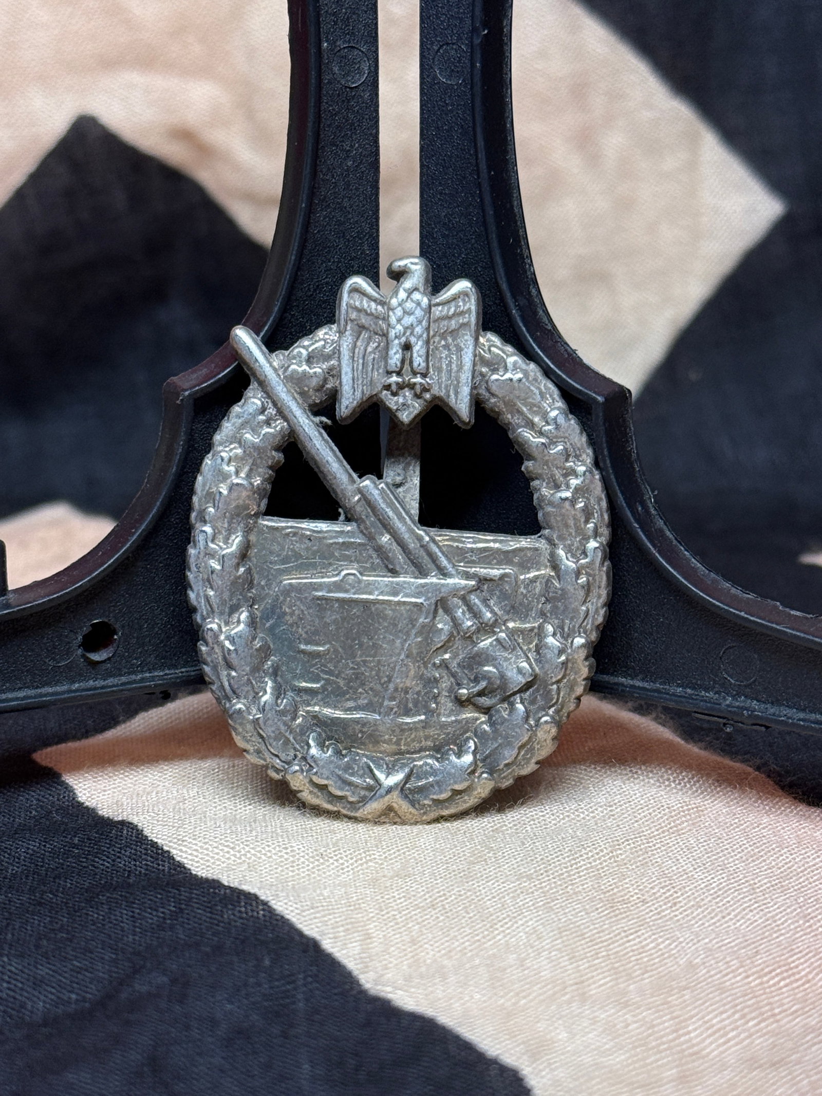 World War II German Infantry Assault Badge, Silver Grade (Schwerin Berlin): German Infantry Assault Badge (Infanterie-Sturmabzeichen) in silvered metal, featuring a Karabiner 98k rifle with fixed bayonet superimposed upon an oval oak-leaf wreath surmounted by a national eagle