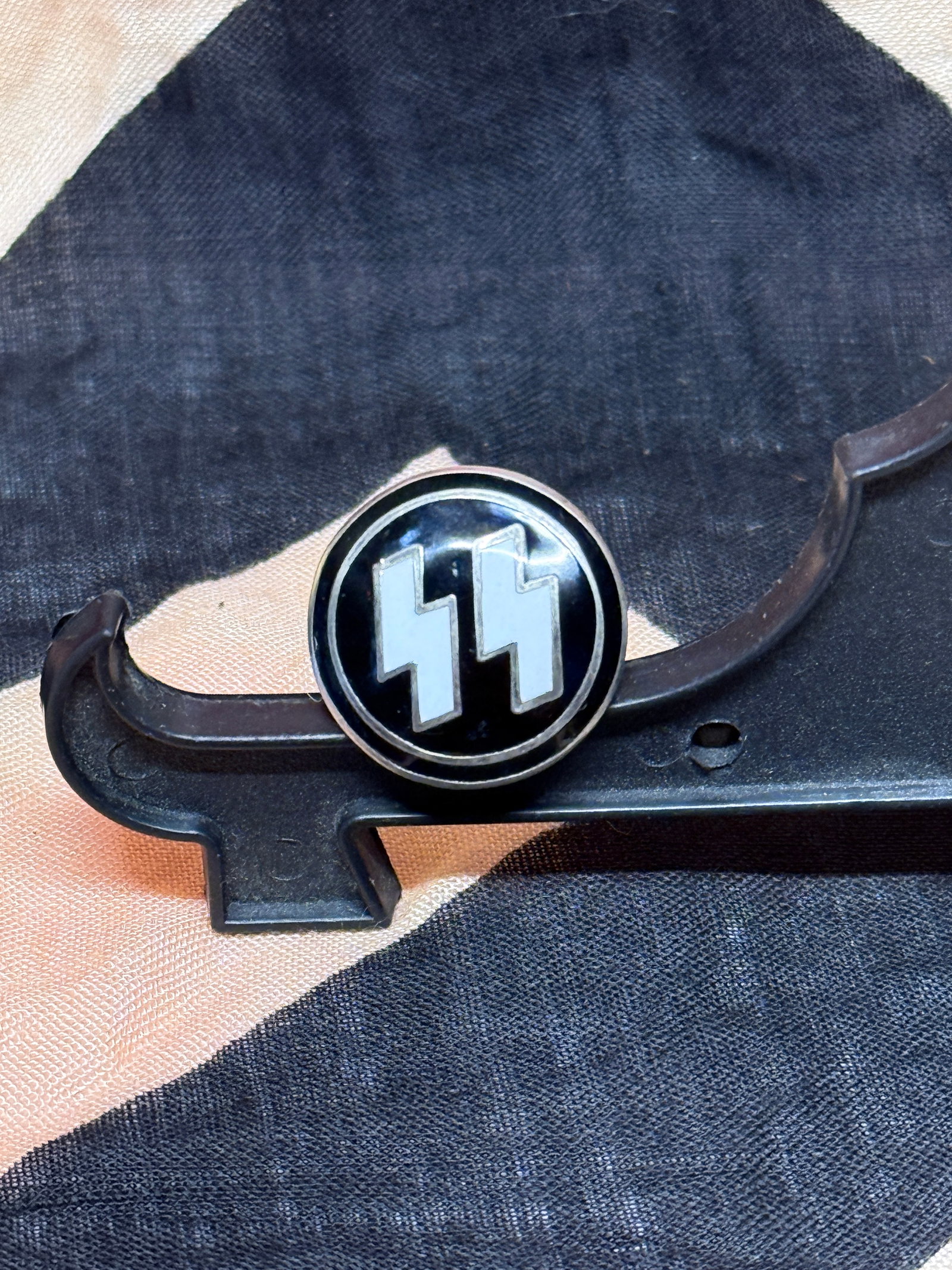 WWII German SS Membership Lapel Pin, M1/4 Marked: This circular enamel lapel badge bears the twin lightning-bolt SS runes in silver against a black background. Worn on civilian clothing, it identified membership or affiliation with the Schutzstaffel 