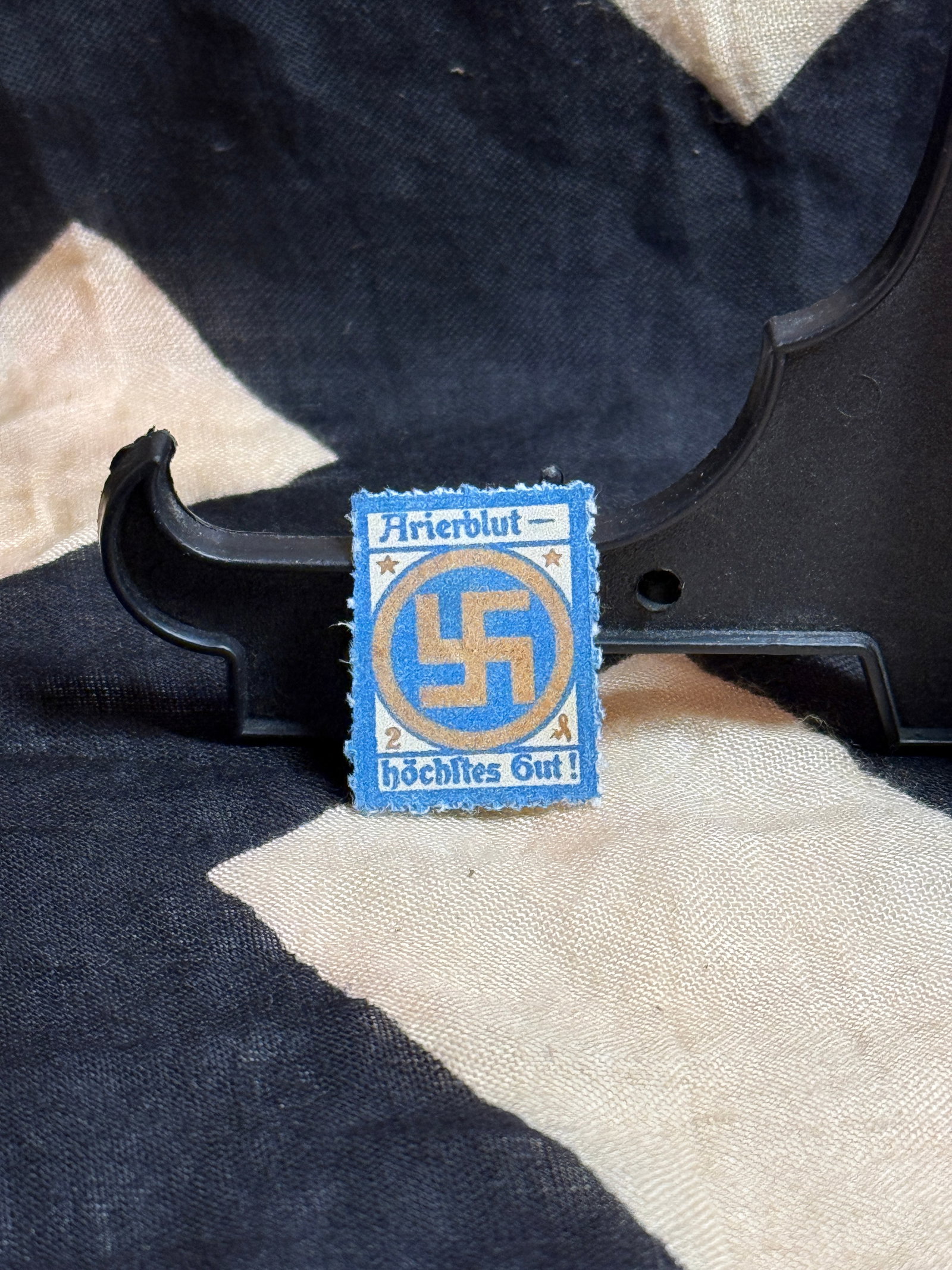 WWII German “Eherblut – Höchstes Gut!?? Propaganda Seal Label: This small printed paper label bears the slogan “Eherblut – höchstes Gut!” (“Pure blood – highest good!”) surrounding a swastika within a decorative border. Such labels were produ