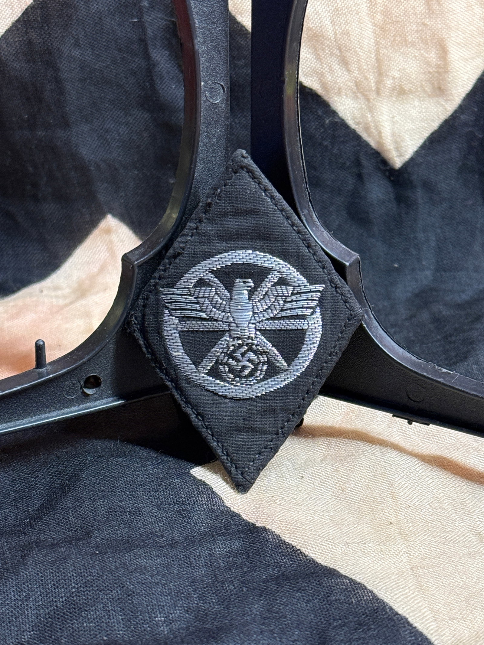 WWII German NSKK Diamond Sleeve Insignia: This black diamond-shaped cloth insignia was worn by members of the National Socialist Motor Corps (NSKK), one of the paramilitary organizations responsible for motor transport training and support wi