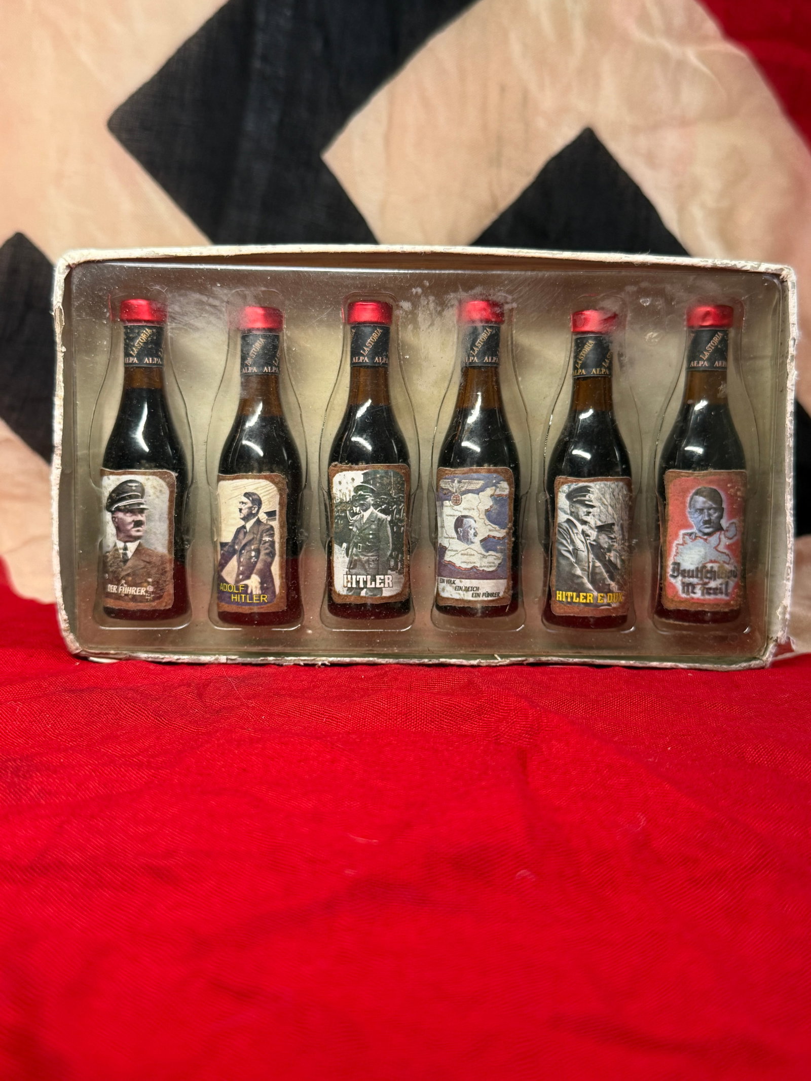 WWII Adolf Hitler Miniature Bottle Display Set: This boxed display contains six miniature novelty bottles decorated with portrait labels depicting Adolf Hitler and various wartime-themed graphics, including captions such as "Der Führer," "Adolf Hi