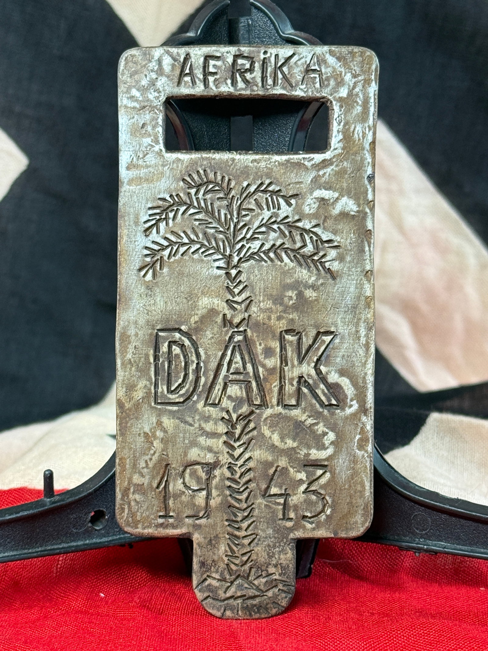 WWII German Afrika Korps DAK 1943 Hand-Carved Wooden Printing Block: This carved wooden printing block features the inscription “AFRIKA” above a palm tree, “DAK” (Deutsches Afrikakorps), and the date “1943”. The reverse is intricately carved wit