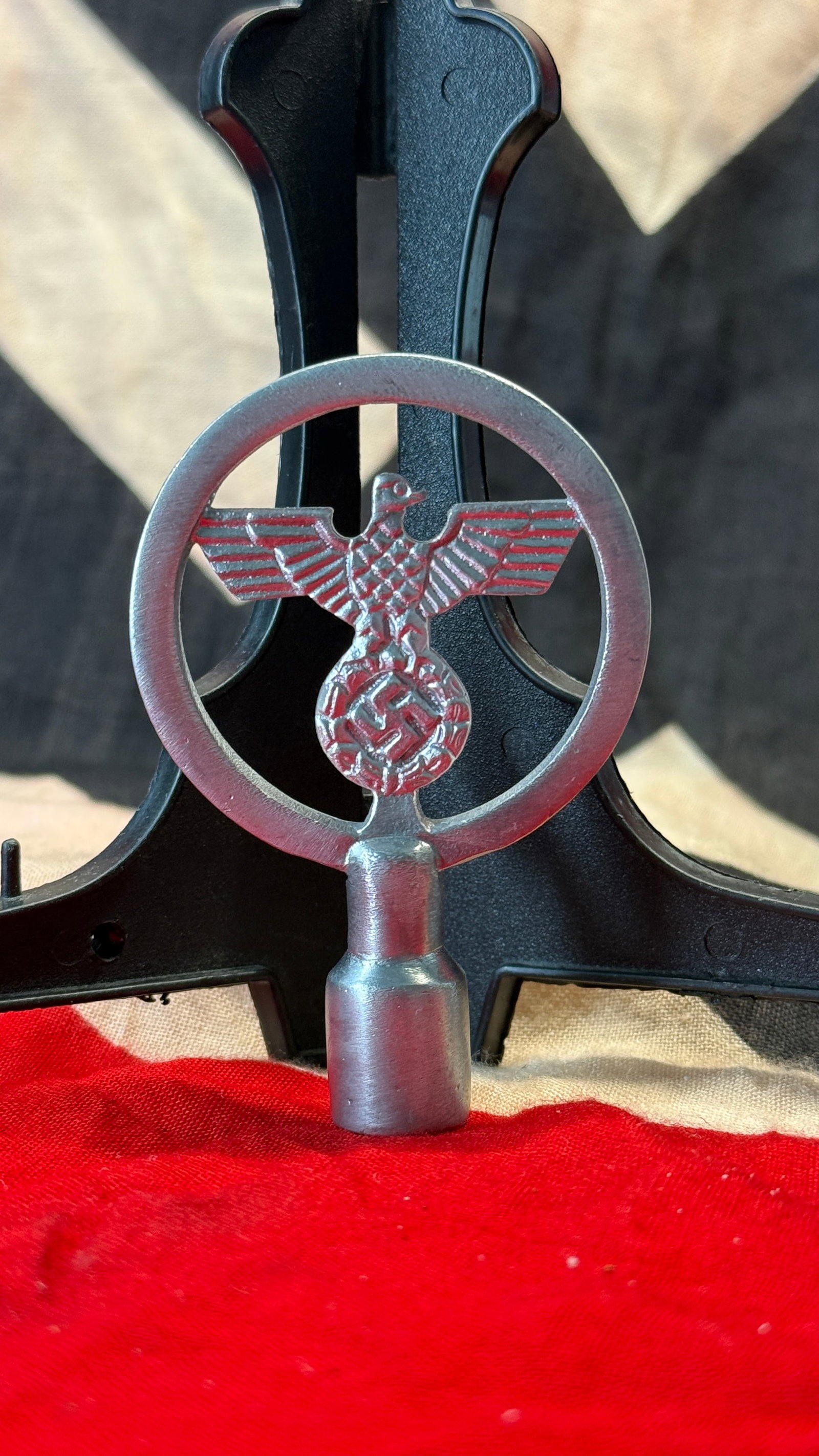 WWII German Reichsadler Flagpole Finial: This cast metal finial features the German national eagle clutching a wreath surrounding a swastika within a circular frame, mounted above a hollow socket designed to fit onto a staff or flagpole. Suc