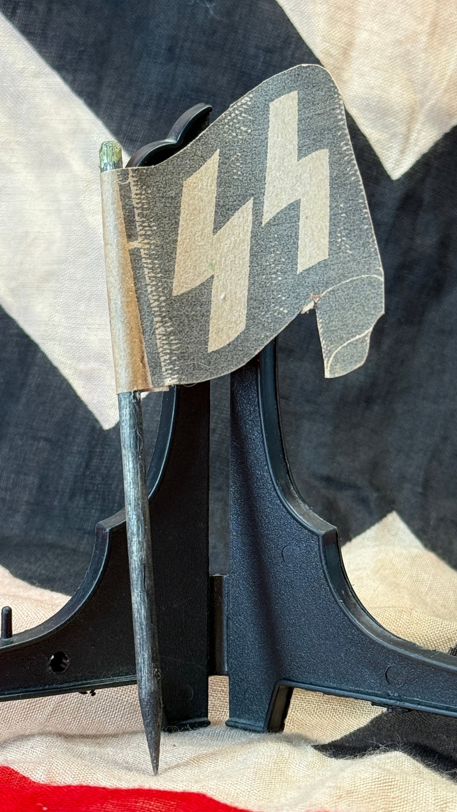 WWII German Waffen-SS Desk Flag: This small tabletop flag displays the distinctive double Sig rune emblem of the Waffen-SS printed on both sides and mounted to its original staff. The reverse bears an RZM acceptance mark with the man