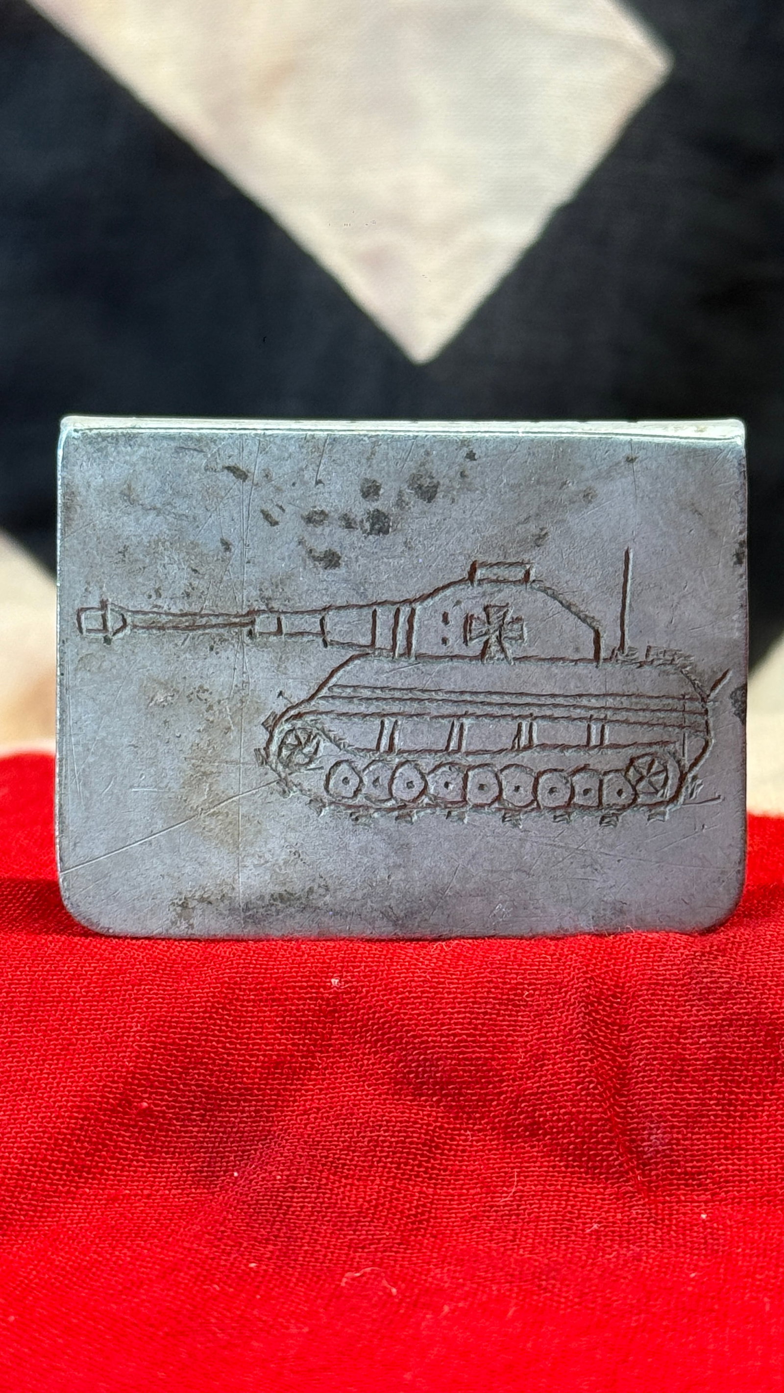 WWII German Eastern Front "Ostfront" Trench Art Matchbox Holder: This handcrafted metal matchbox holder is engraved with the profile of a German armored fighting vehicle and the word "OSTFRONT" along one edge. Constructed from sheet metal with folded sides, it refl