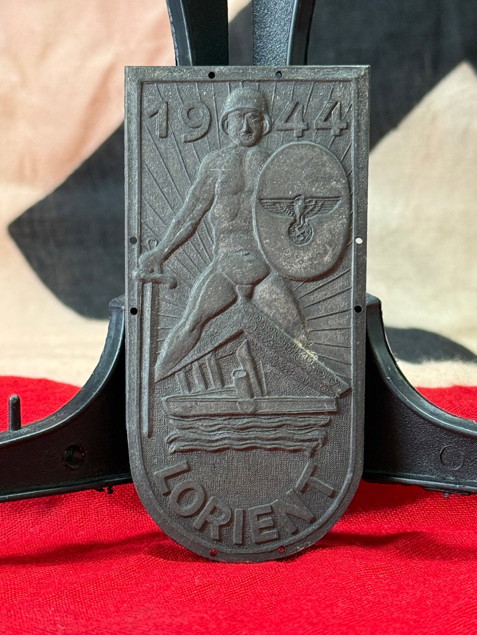 WWII German 1944 "TORIEN" Commemorative Plaque Sleeve Shield: This World War II German molded commemorative plaque depicts a helmeted warrior carrying a sword and shield bearing the national eagle above a stylized vessel, with the date 1944 prominently displayed
