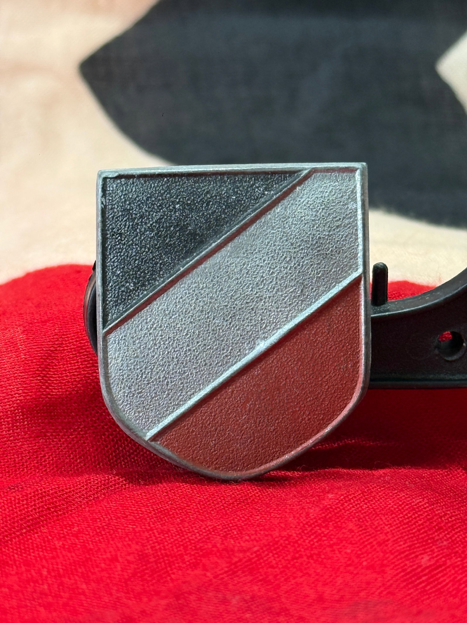 WWII German Tropical Pith Helmet National Tricolor Shield: This World War II German national tricolor shield features the traditional black, white, and red diagonal color arrangement in a pressed shield form with its original vertical pin attachment on the re